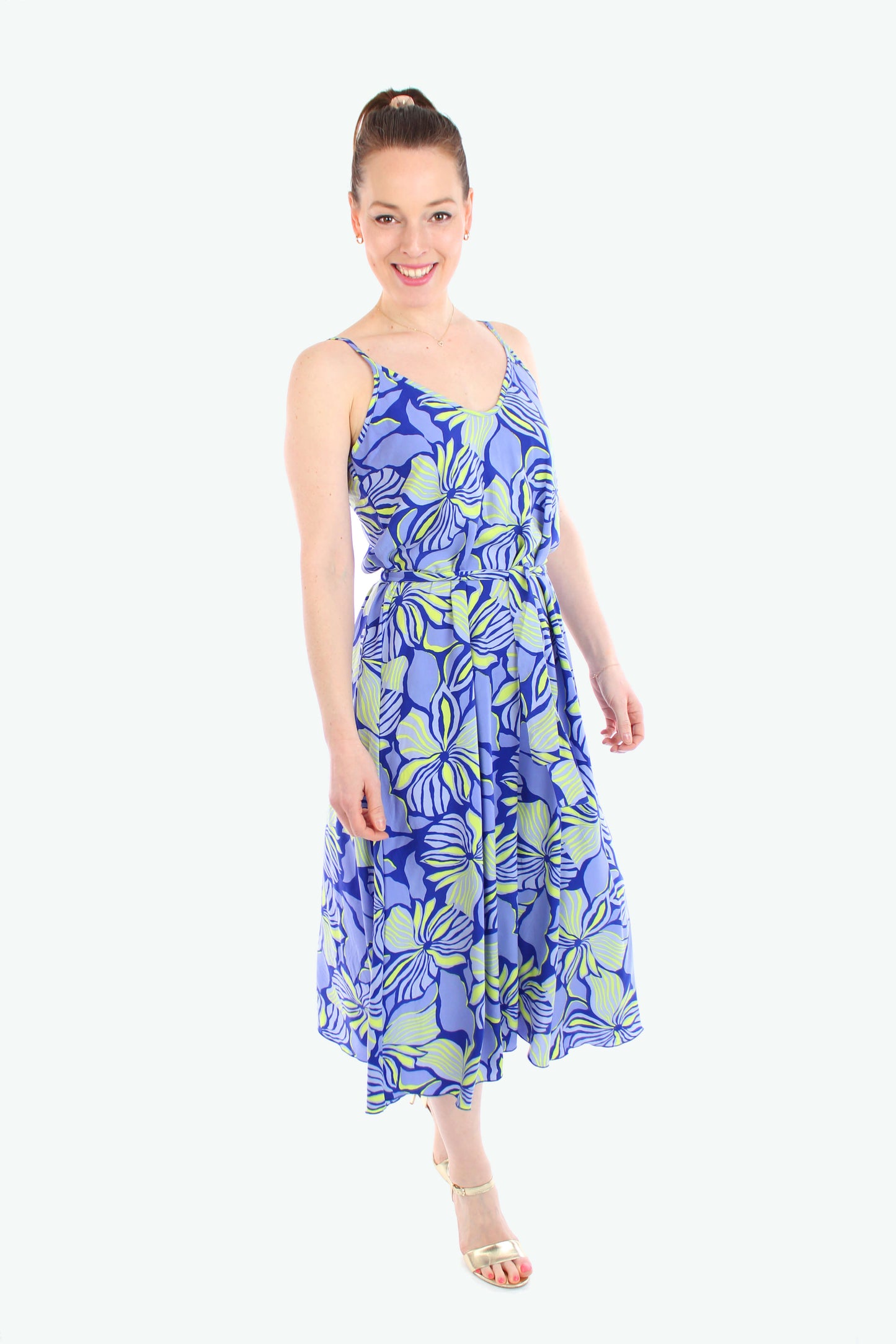 Frau trägt ein ärmelloses Midikleid mit blau-gelb geblümtem Muster und schmalen Trägern – leichtes Sommerkleid 2025 von LA.LUKA Berlin.