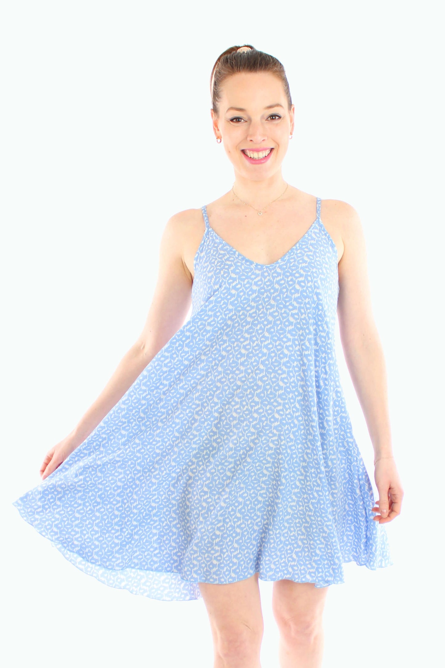 Frau trägt ein leichtes Sommerkleid mit Spaghettiträgern in Hellblau mit weißem Muster von LA.LUKA Berlin – schwingender Schnitt, ideal für heiße Tage im Sommer 2025.