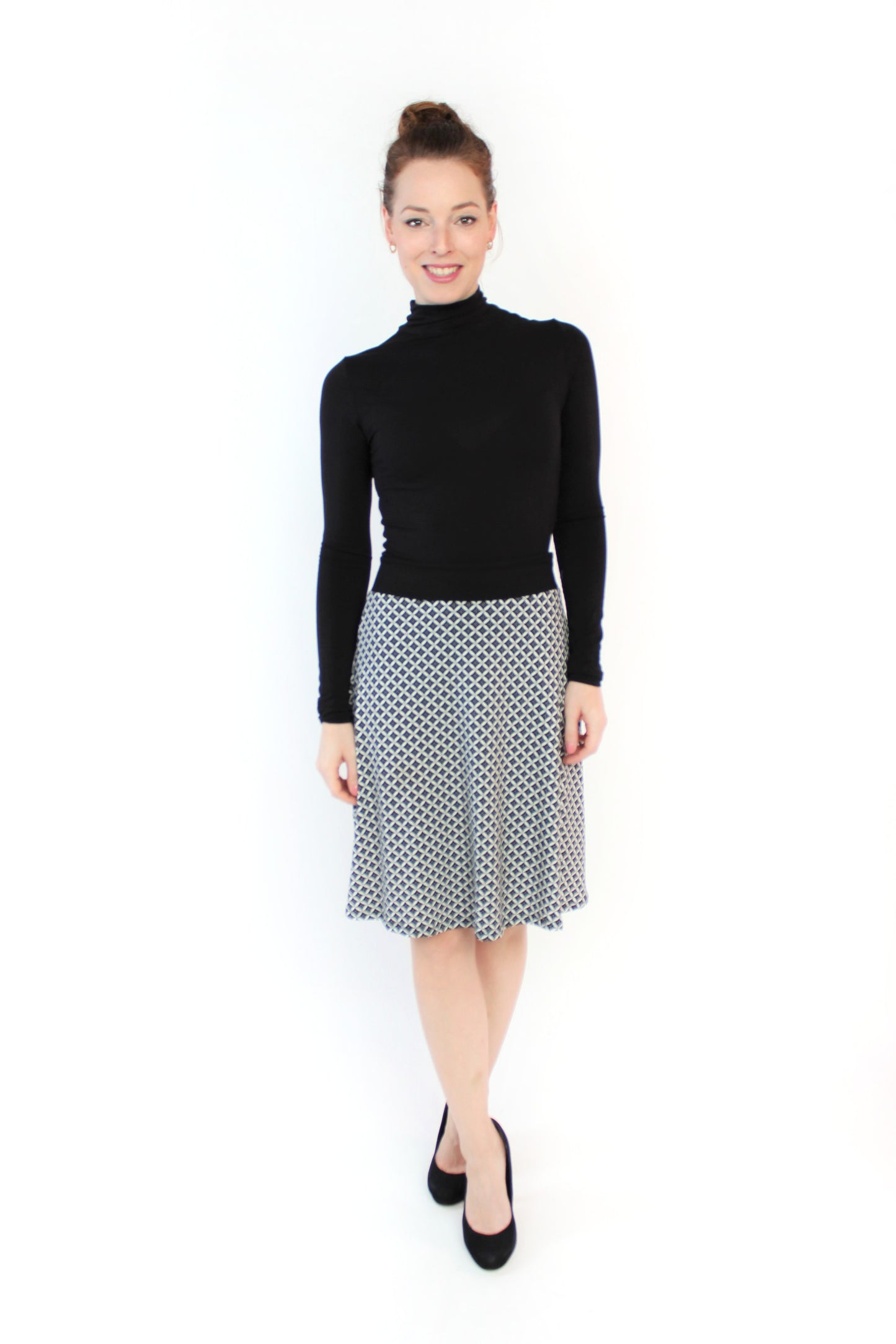 Frau in einem knielangen A-Linienrock in schwarz/weiß aus Viskosejersey von LA.LUKA Berlin.