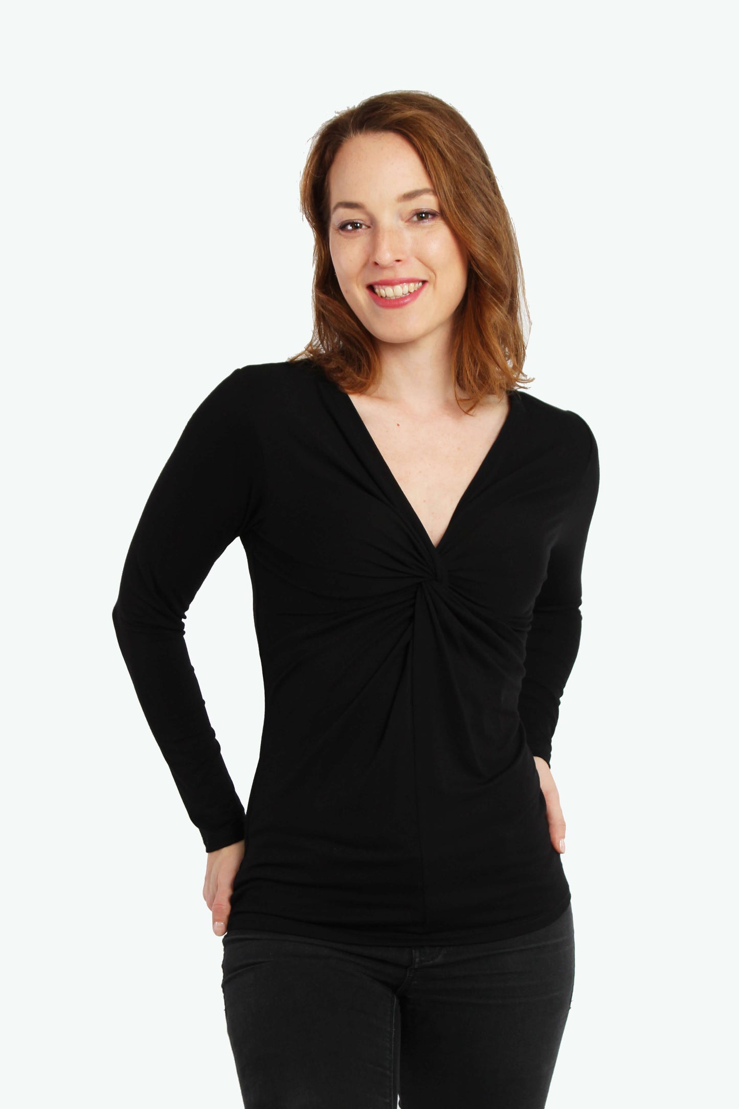 Frau in einem schwarzen Knotenshirt aus Viskosejersey mit langen Ärmeln von LA.LUKA Berlin.