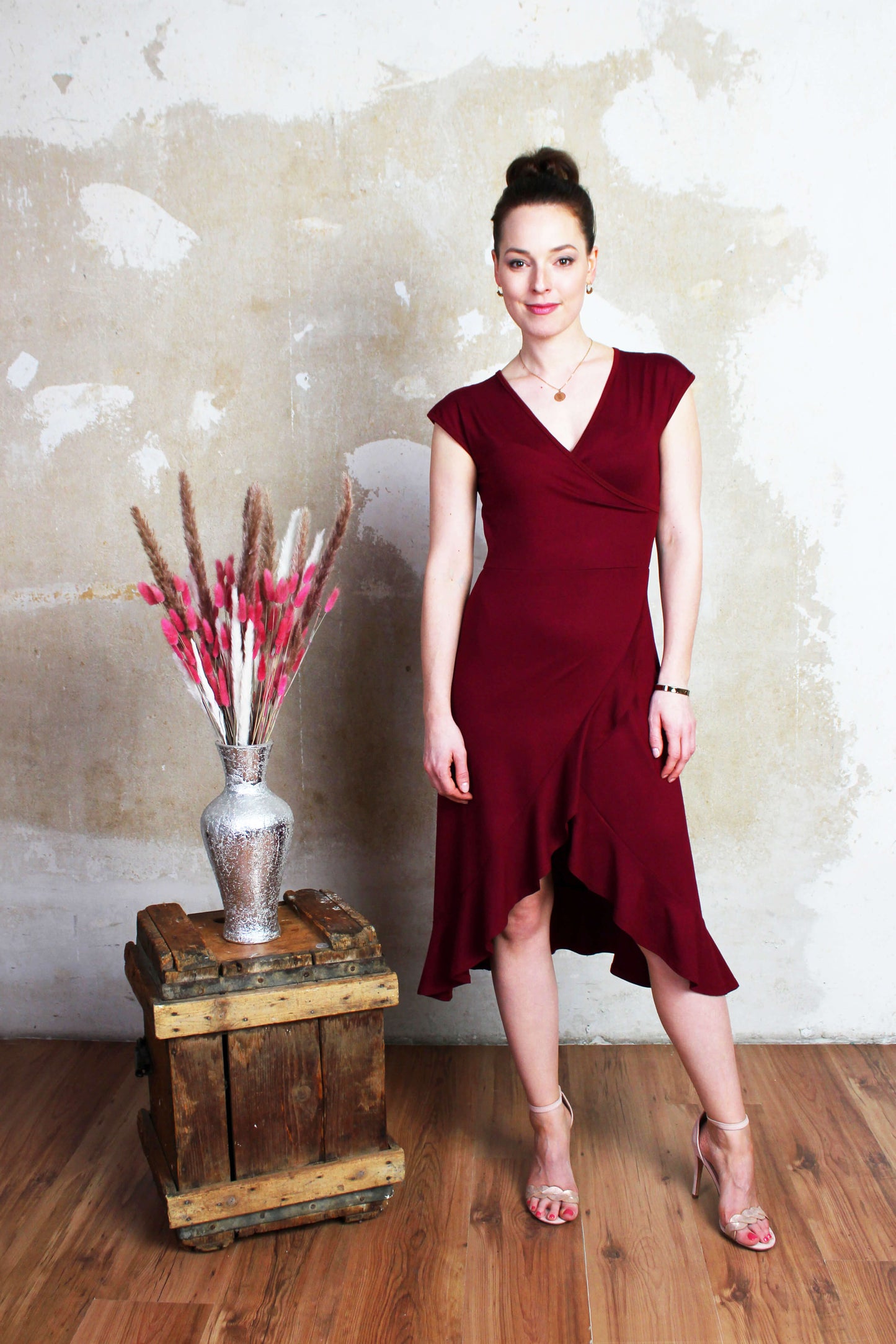 Frau in einem eleganten Midikleid mit Volants bordeauxrot aus Viskosejersey von LA.LUKA Berlin.