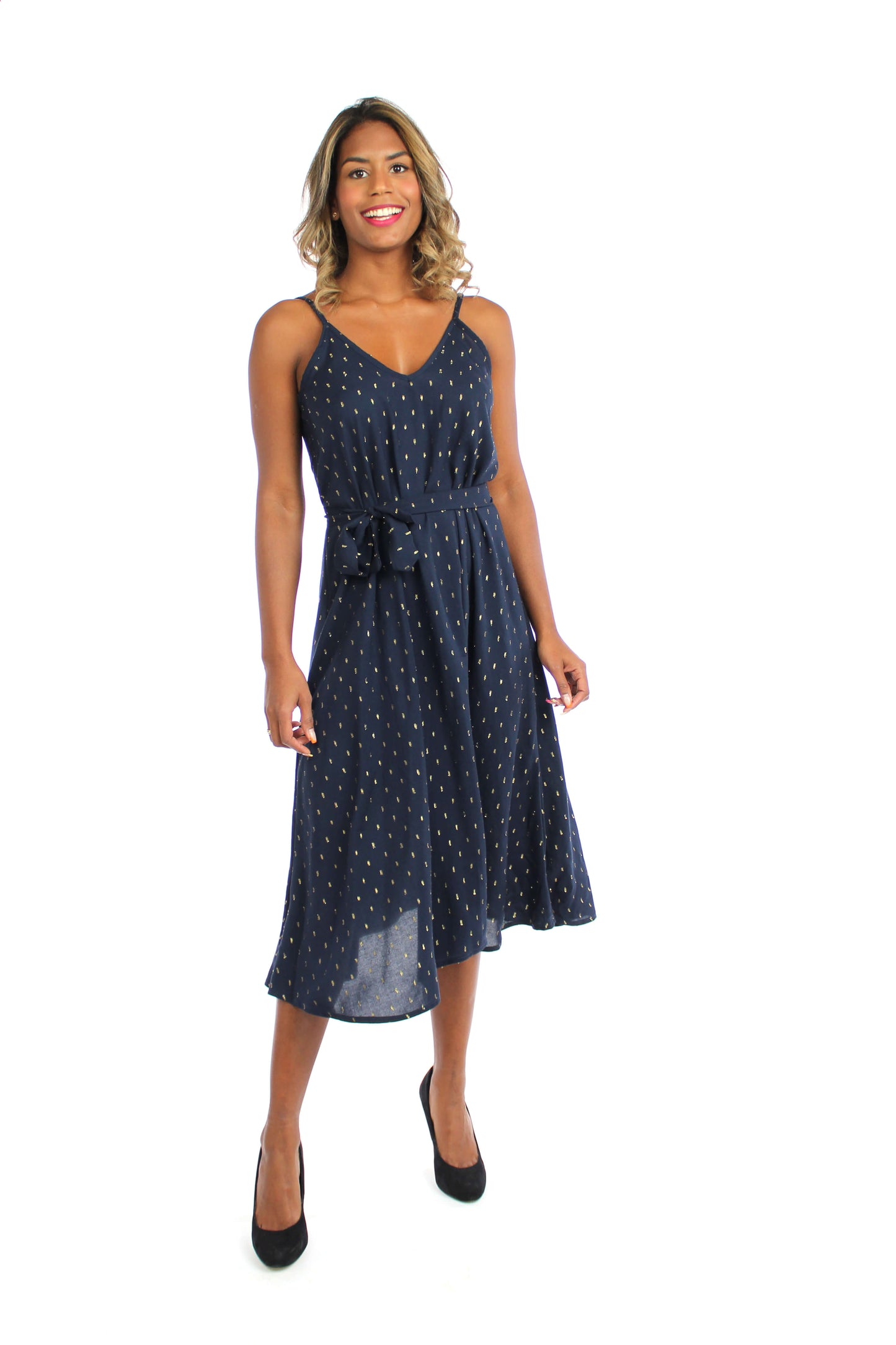 Frau, in einem eleganten, dunkelblauen Midikleid mit goldenen Punkten und Spaghettiträgern aus Viskosestoff.