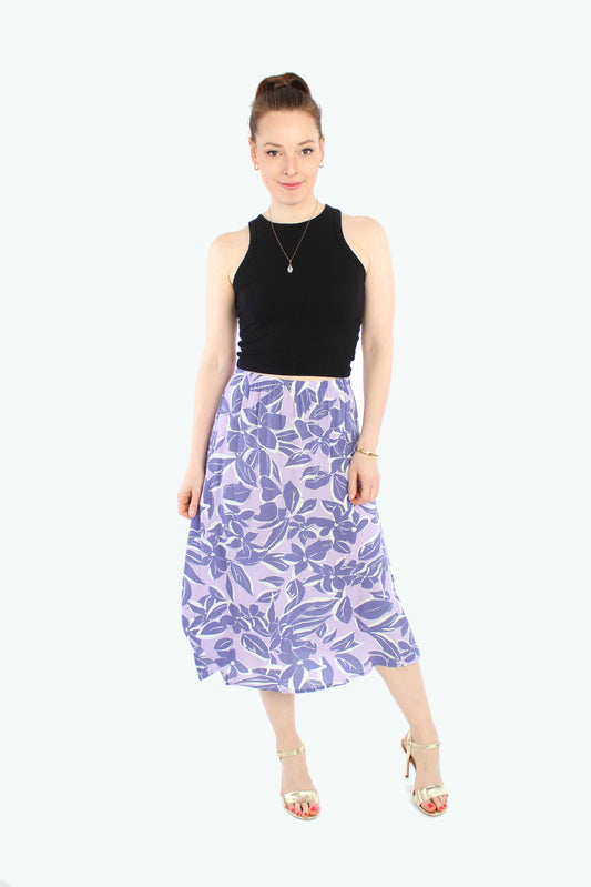 Model, in einem leichten Midirock in flieder mit lila Blumen aus Viskose Crepe von LA.LUKA Berlin.