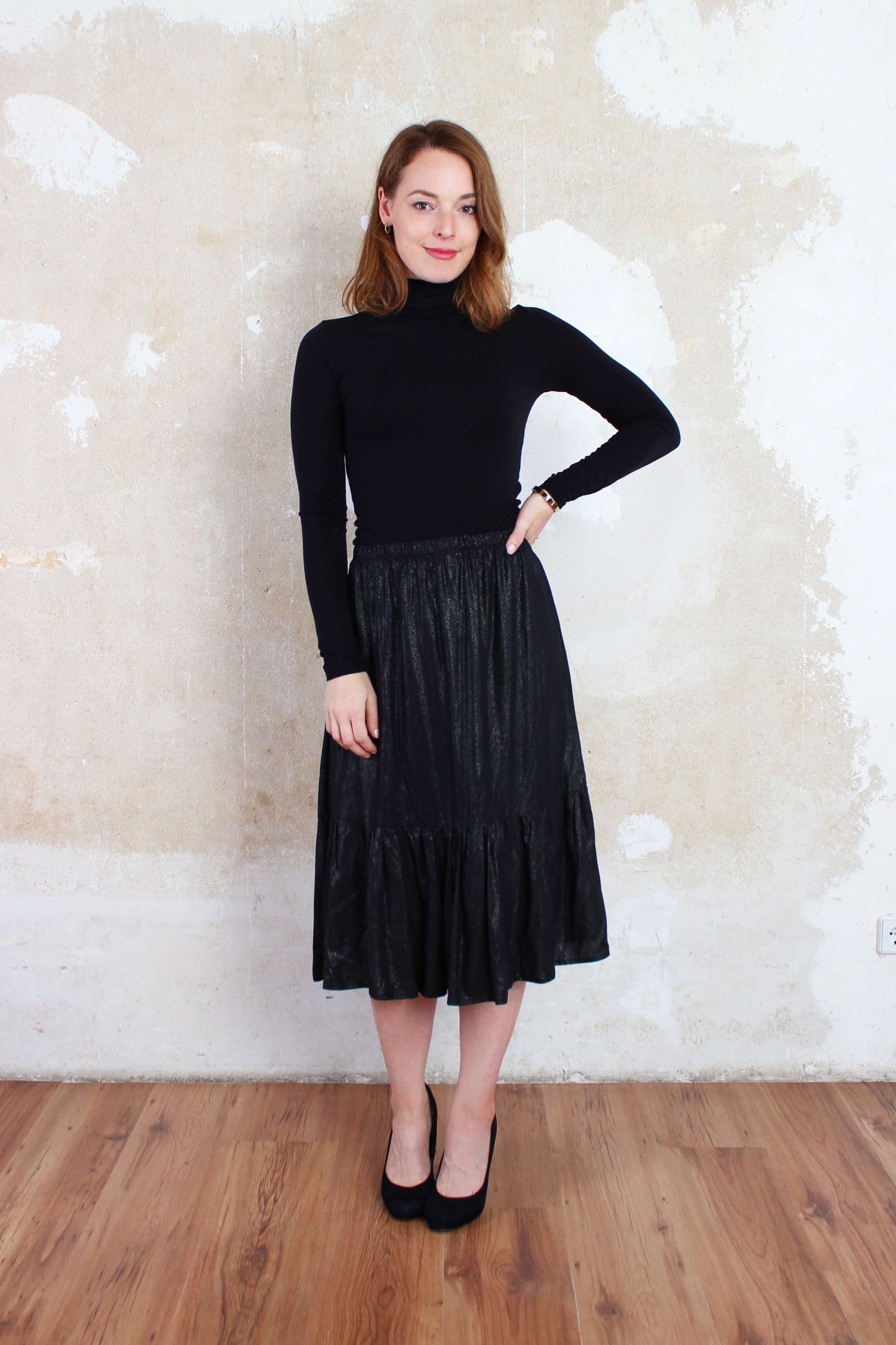 Eleganter, glänzender Midirock in schwarz mit Volantsaum von LA.LUKA Berlin.