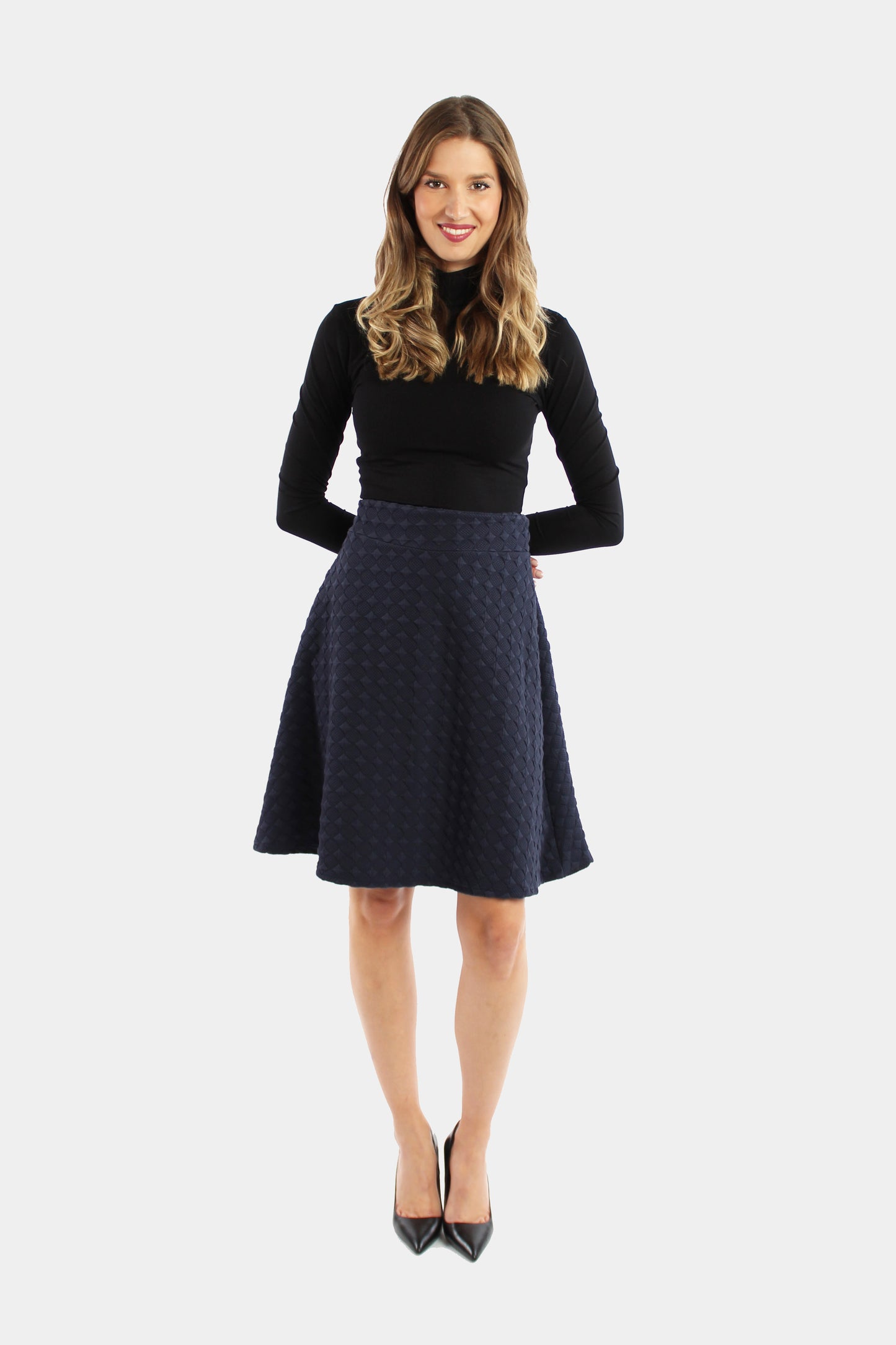 Eine Frau präsentiert sich in einem eleganten, dunkelblauen A-Linienrock aus festem Jersey. Ein stilvolles Outfit für besondere Anlässe und einen bleibenden Eindruck.