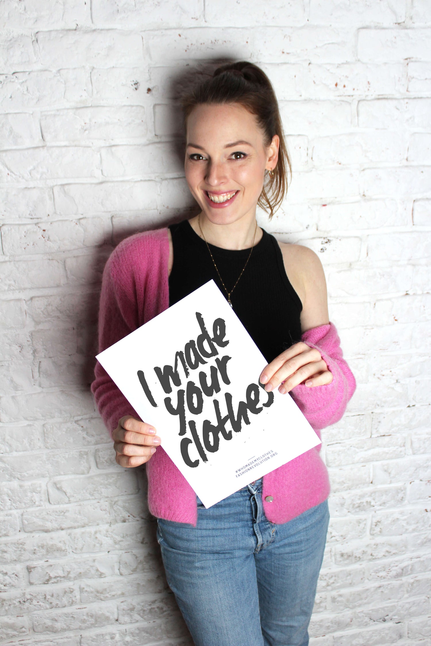 Modedesignerin, hält "i made your clothes" Schild in der Hand.