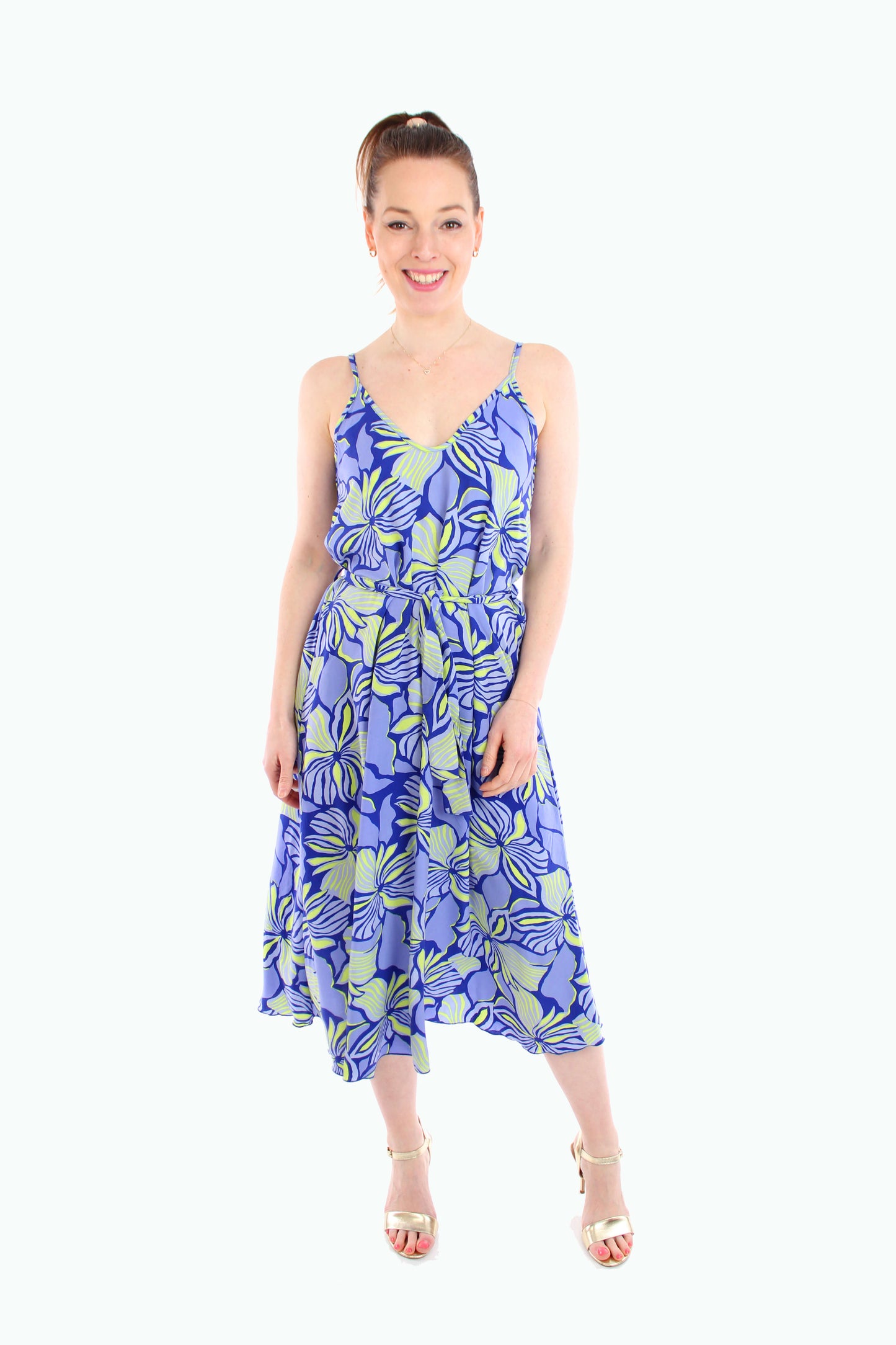 Frau trägt ein luftiges blaues Midikleid mit neonfarbenem Blumenprint und Bindegürtel – perfektes Sommerkleid 2025.