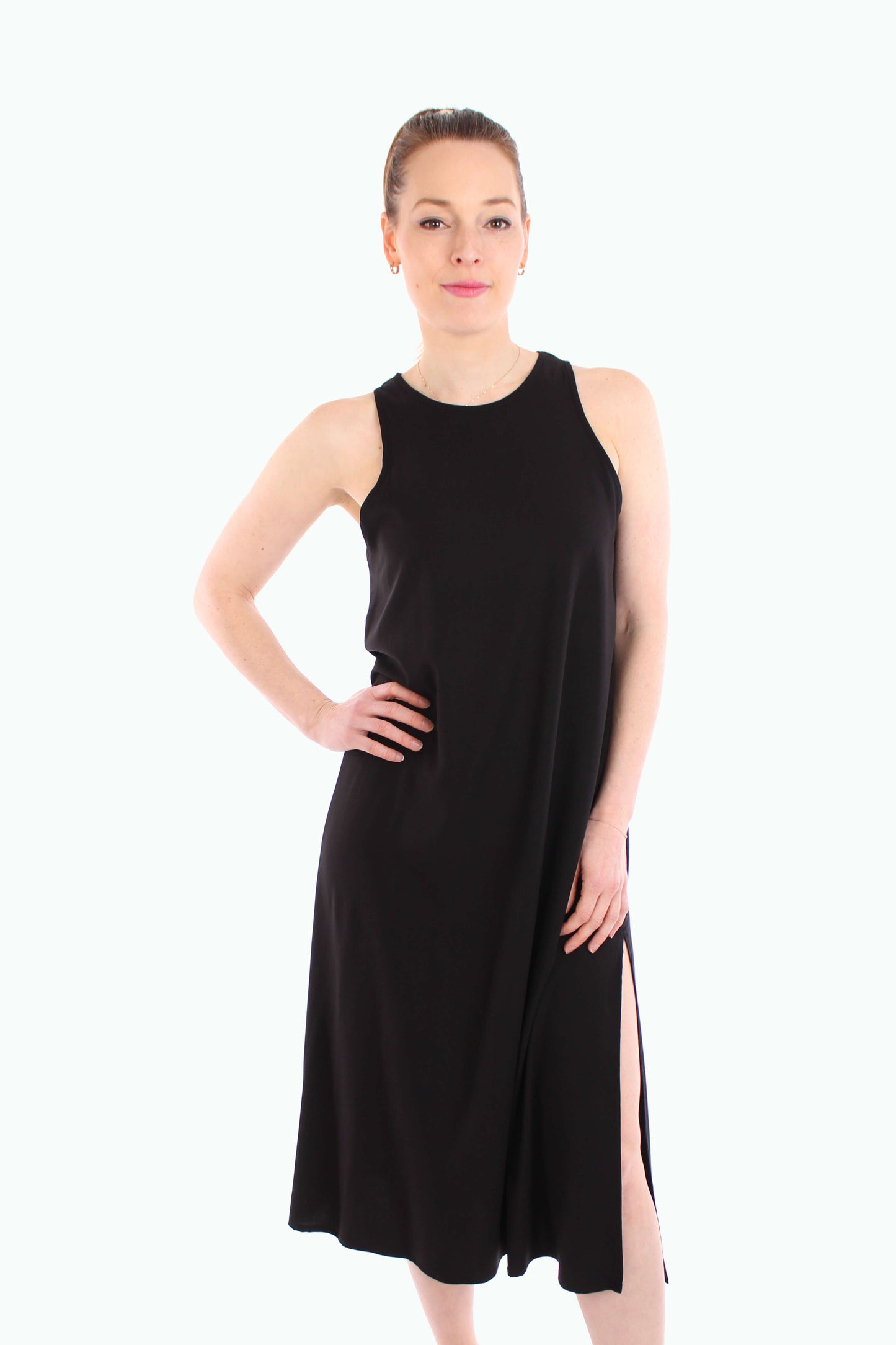 Frau trägt ein schwarzes Sommerkleid in Midilänge aus Viskose-Stretch, locker geschnitten mit seitlichem Schlitz.
