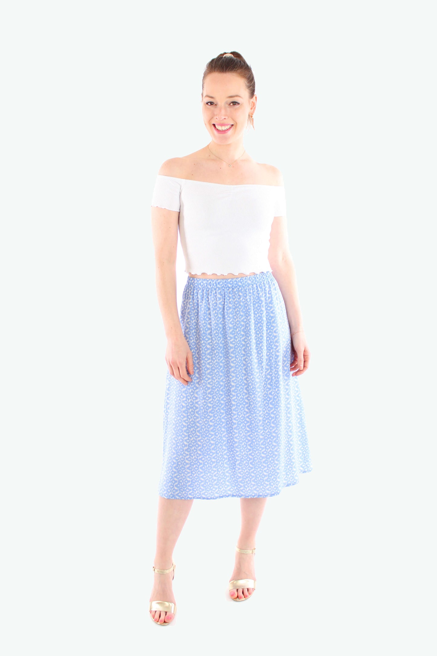 Leichter Damen-Midirock in Hellblau mit weißem Leo-Print, kombiniert mit einem weißen Off-Shoulder-Top – ideal für feminine Sommerlooks.