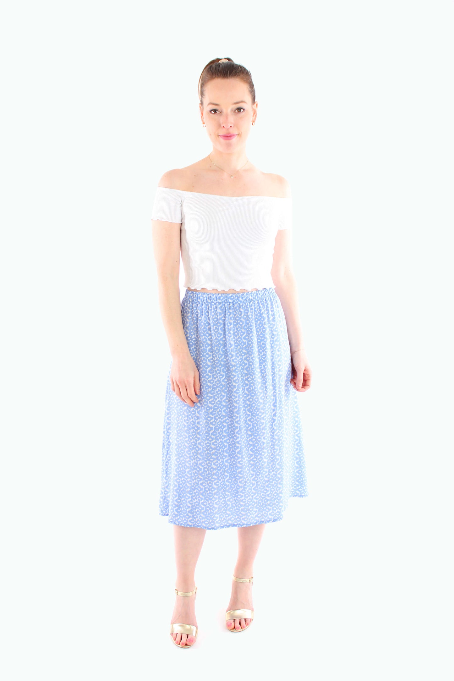 Leichter Damen-Midirock in Hellblau mit weißem Leo-Print, kombiniert mit einem weißen Off-Shoulder-Top – ideal für feminine Sommerlooks.