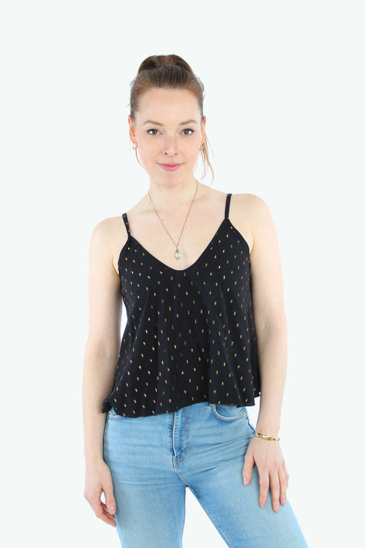 Frau, in einem Croptop in schwarz mit goldenen Punkten und mit Spaghettiträgern von LA.LUKA Berlin.