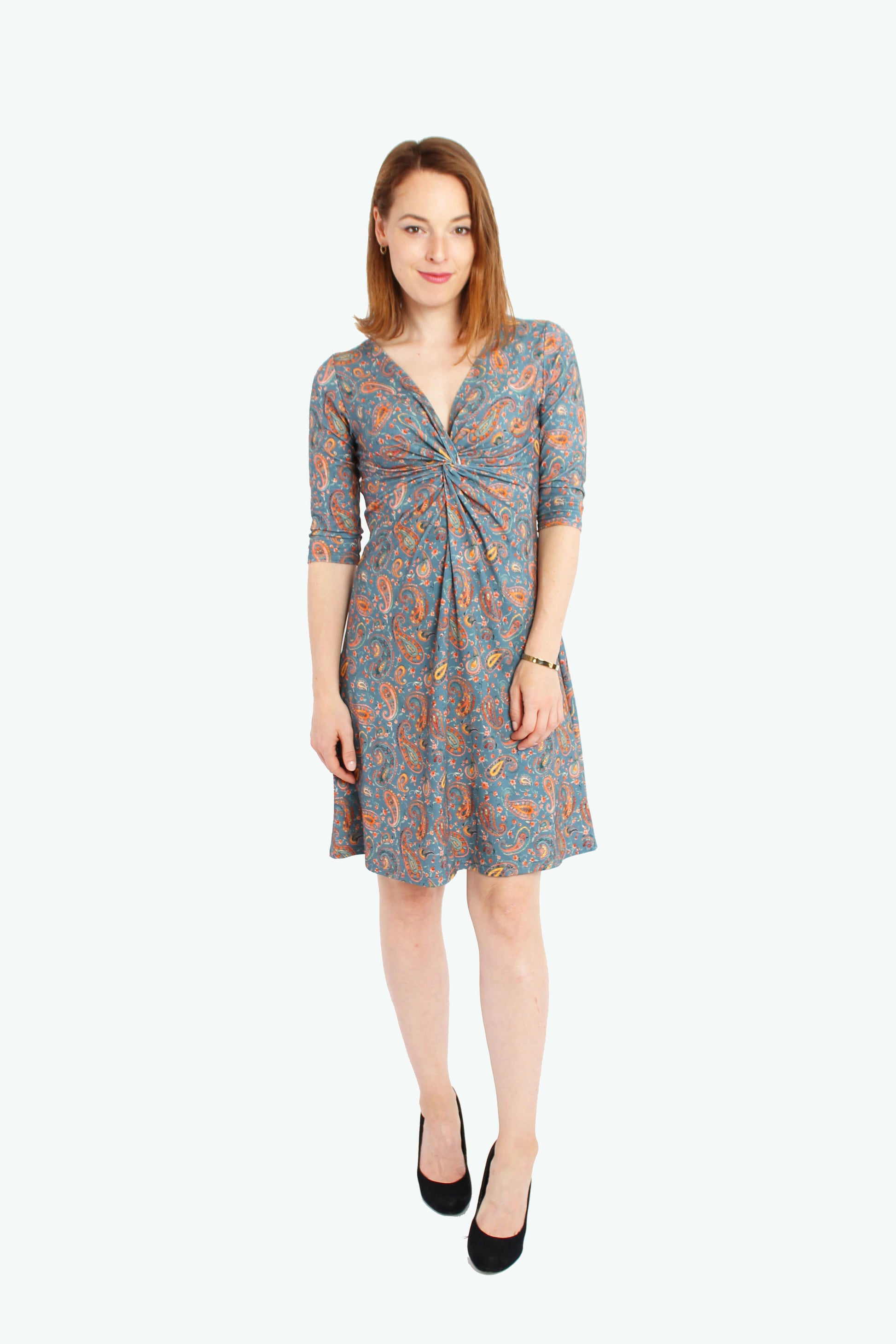 Frau in einem knielangen Knotenkleid in jeansblau mit Paisleymuster aus Baumwolle von LA.LUKA Berlin.