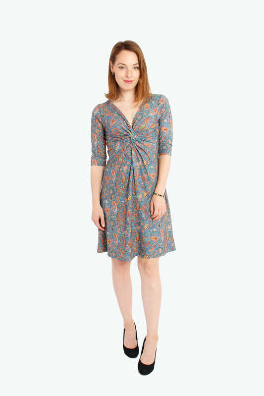 Frau in einem knielangen Knotenkleid in jeansblau mit Paisleymuster aus Baumwolle von LA.LUKA Berlin.