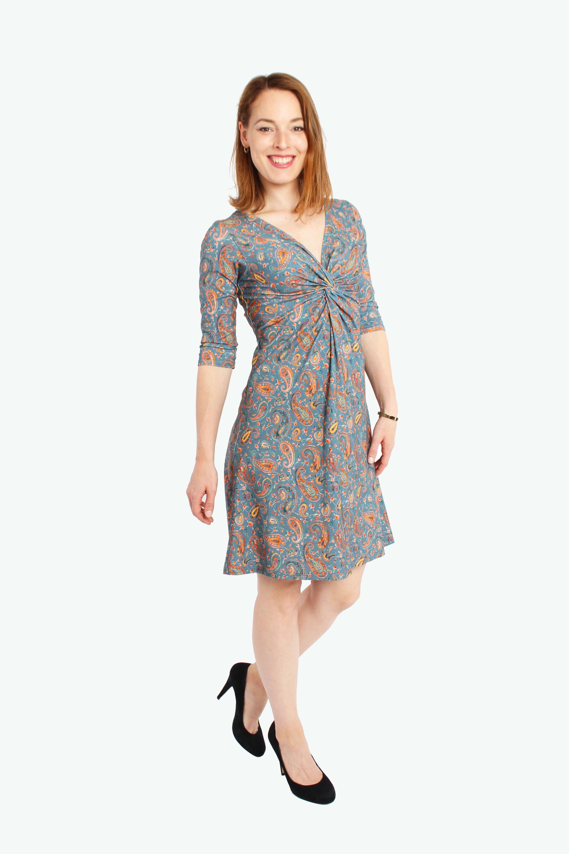 Frau in einem knielangen Knotenkleid in jeansblau mit Paisleymuster aus Baumwolle von LA.LUKA Berlin.