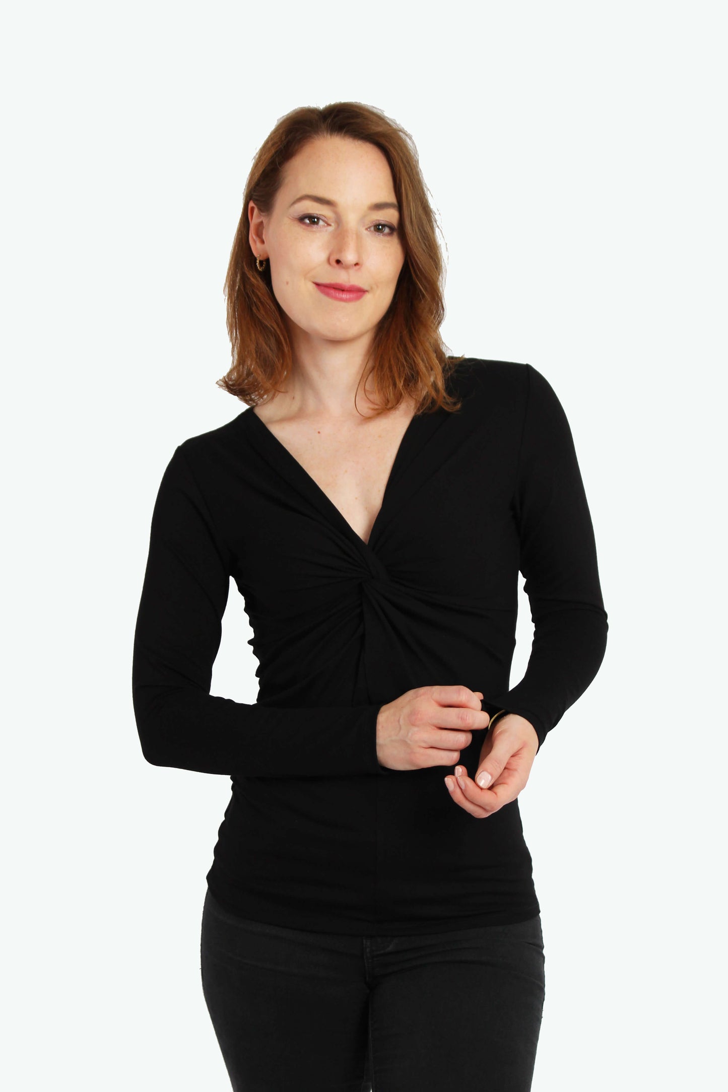 Frau in einem schwarzen Knotenshirt aus Viskosejersey mit langen Ärmeln von LA.LUKA Berlin.