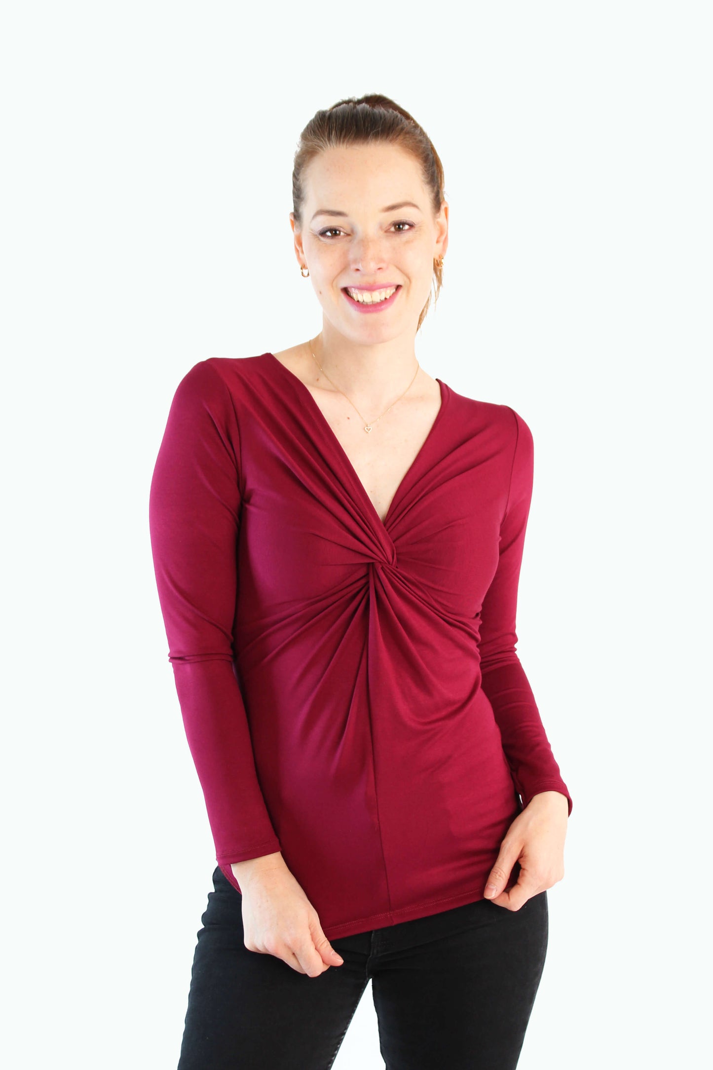 Model trägt bordeauxfarbenes Longsleeve mit Twist-Detail und V-Ausschnitt von LA.LUKA Berlin, auf hellem Hintergrund – stylisch, feminin & fair produziert.