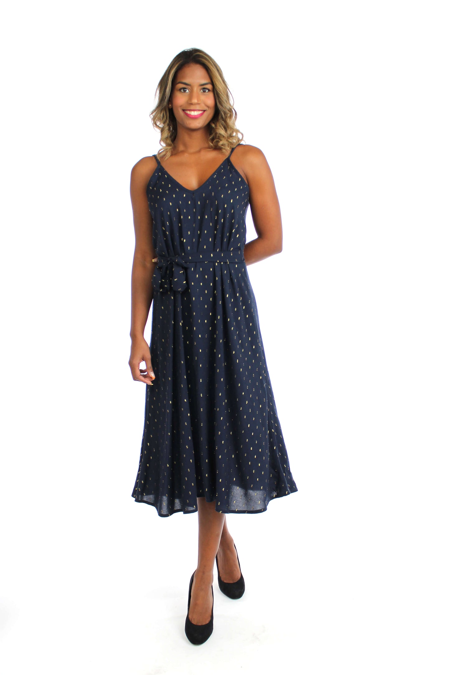 Frau, in einem eleganten, dunkelblauen Midikleid mit goldenen Punkten und Spaghettiträgern.