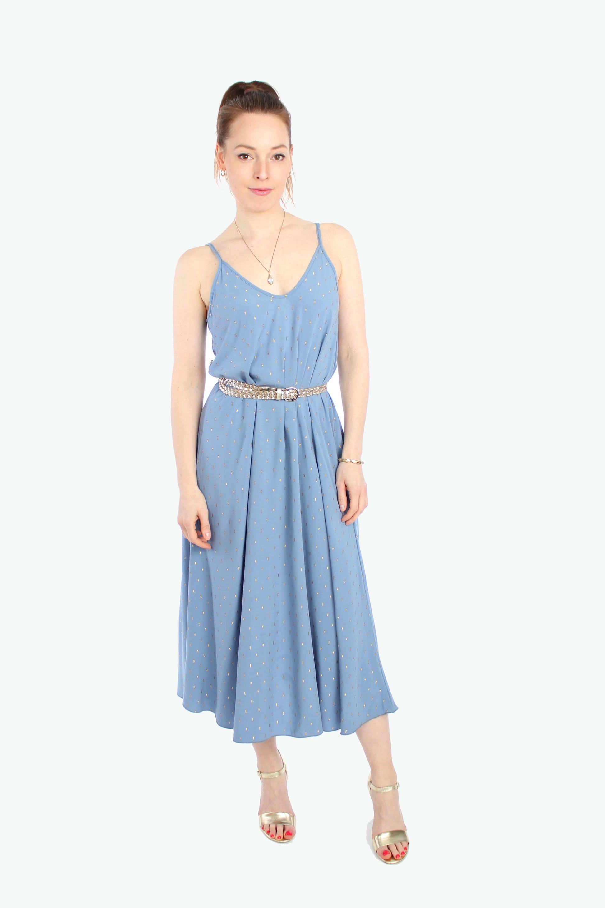 Frau, in einem hellblauen Sommerkleid in Midilänge mit goldenen Pünktchen mit Spaghettiträgern aus leichtem Viskosestoff von LA.LUKA Berlin.