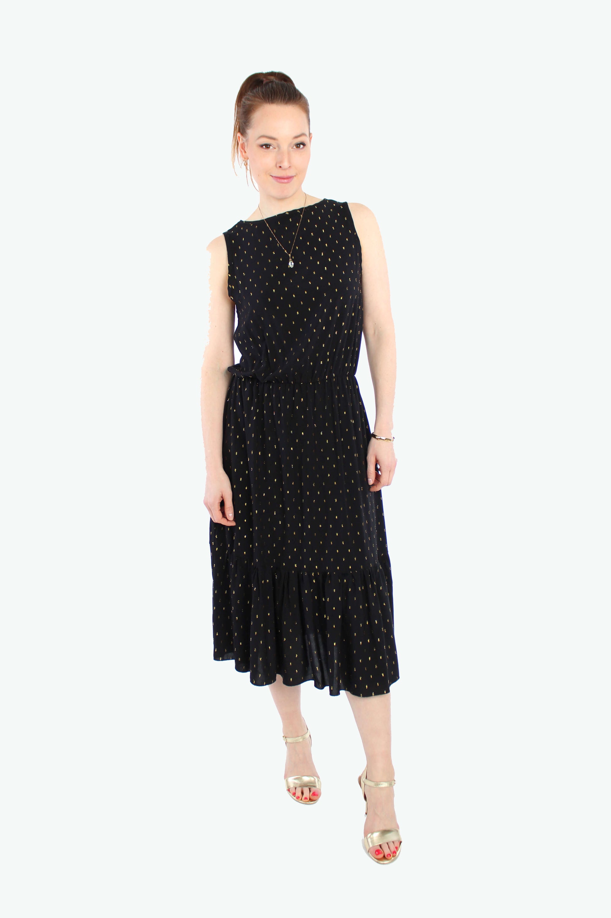 Frau, in einem eleganten Midikleid in schwarz mit goldenen Pünktchen und Volant aus leichtem Viskosestoff von LA.LUKA Berlin.