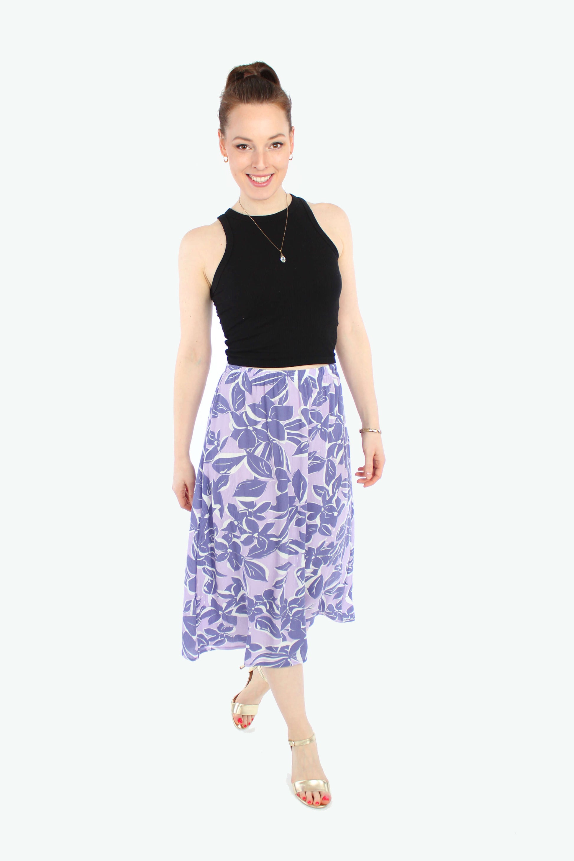 Model, in einem leichten Midirock in flieder mit lila Blumen aus Viskose Crepe von LA.LUKA Berlin.