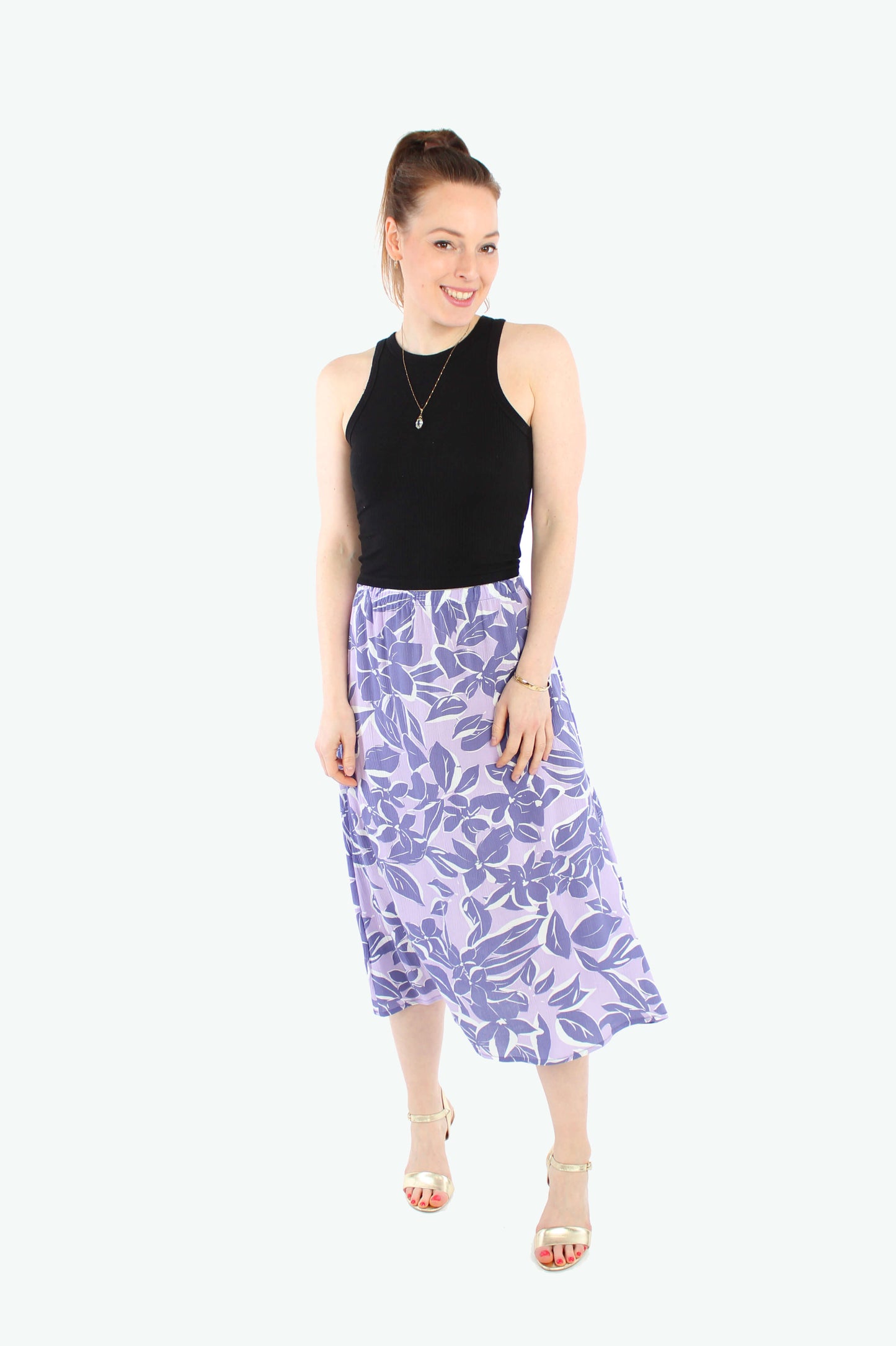 Model, in einem leichten Midirock in flieder mit lila Blumen aus Viskose Crepe von LA.LUKA Berlin.