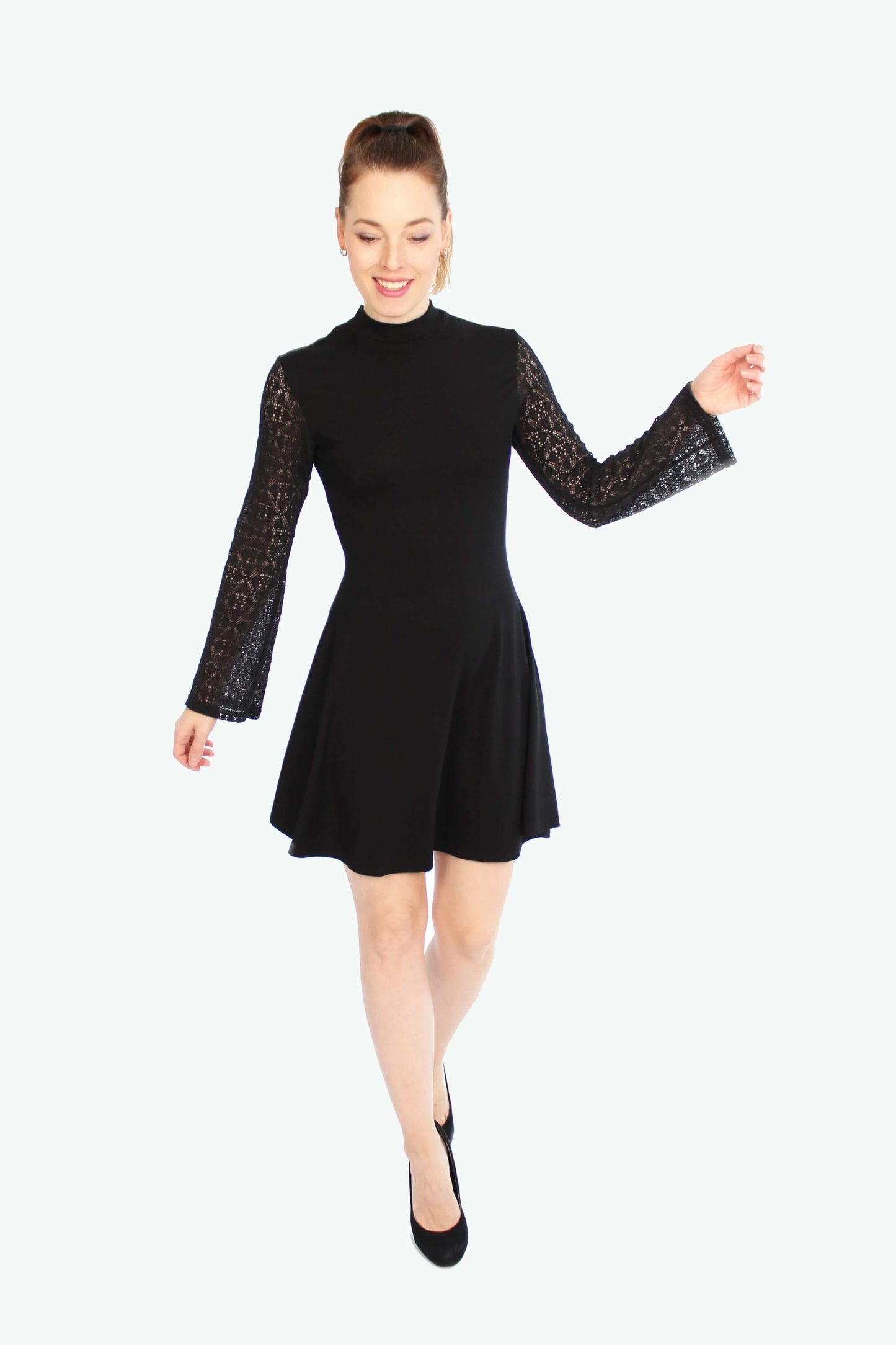 Model in schwarzem Minikleid mit Spitzenärmeln, Stehkragen und leicht ausgestelltem Rock, von LA.LUKA Berlin – seitliche Bewegung, herbstlicher Look