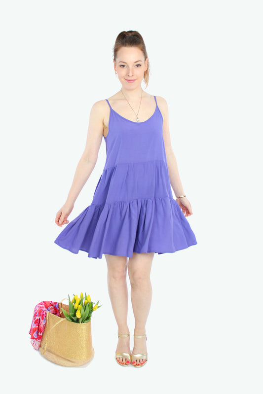 Model, in einem Sommerkleid in lila mit Volants und Spaghettiträgern aus leichten Viskosestoff von LA.LUKA Berlin.