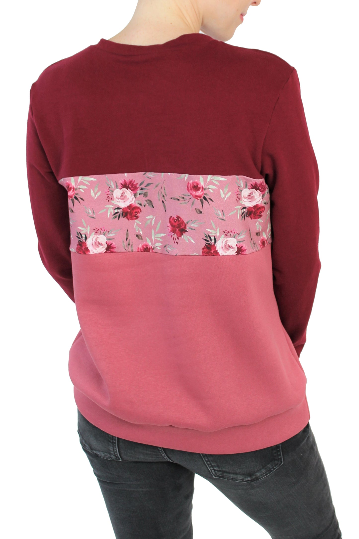 Model trägt einen Pullover aus Baumwolle in bordeaux und rosé mit Blumenprint von LA.LUKA Berlin in der Rückansicht.