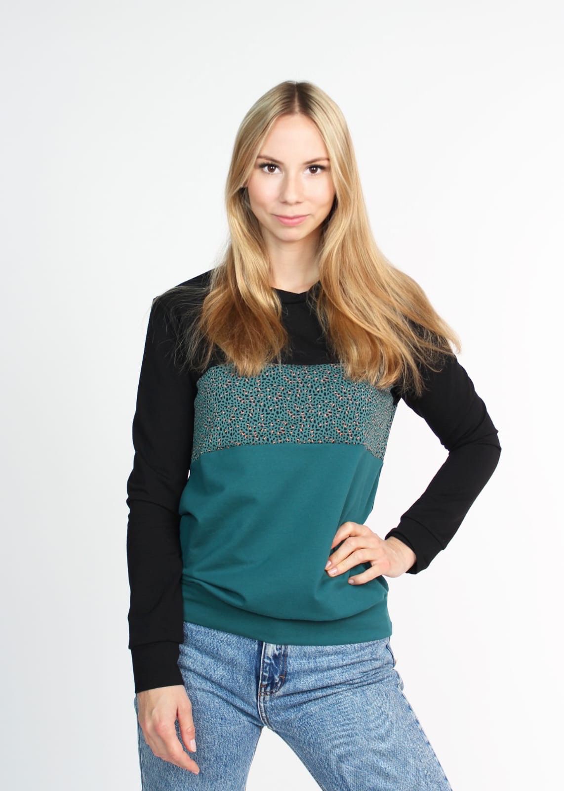Model trägt einen Pullover mit Rundhalsausschnitt in dunkelgrün und schwarz von LA.LUKA Berlin. 