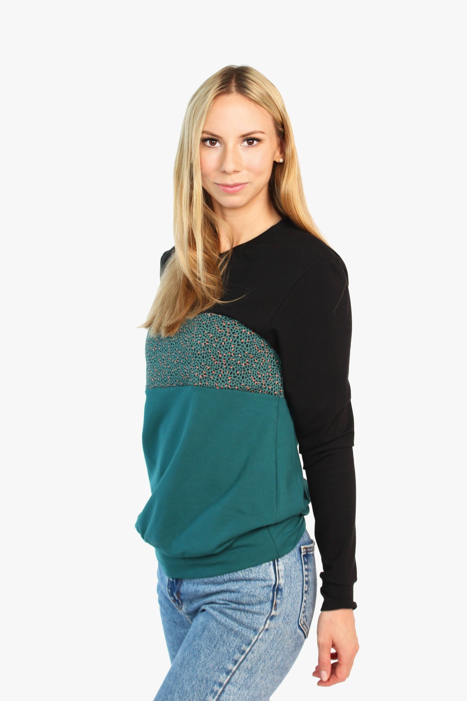 Model trägt einen Pullover mit Rundhalsausschnitt in dunkelgrün und schwarz von LA.LUKA Berlin. 