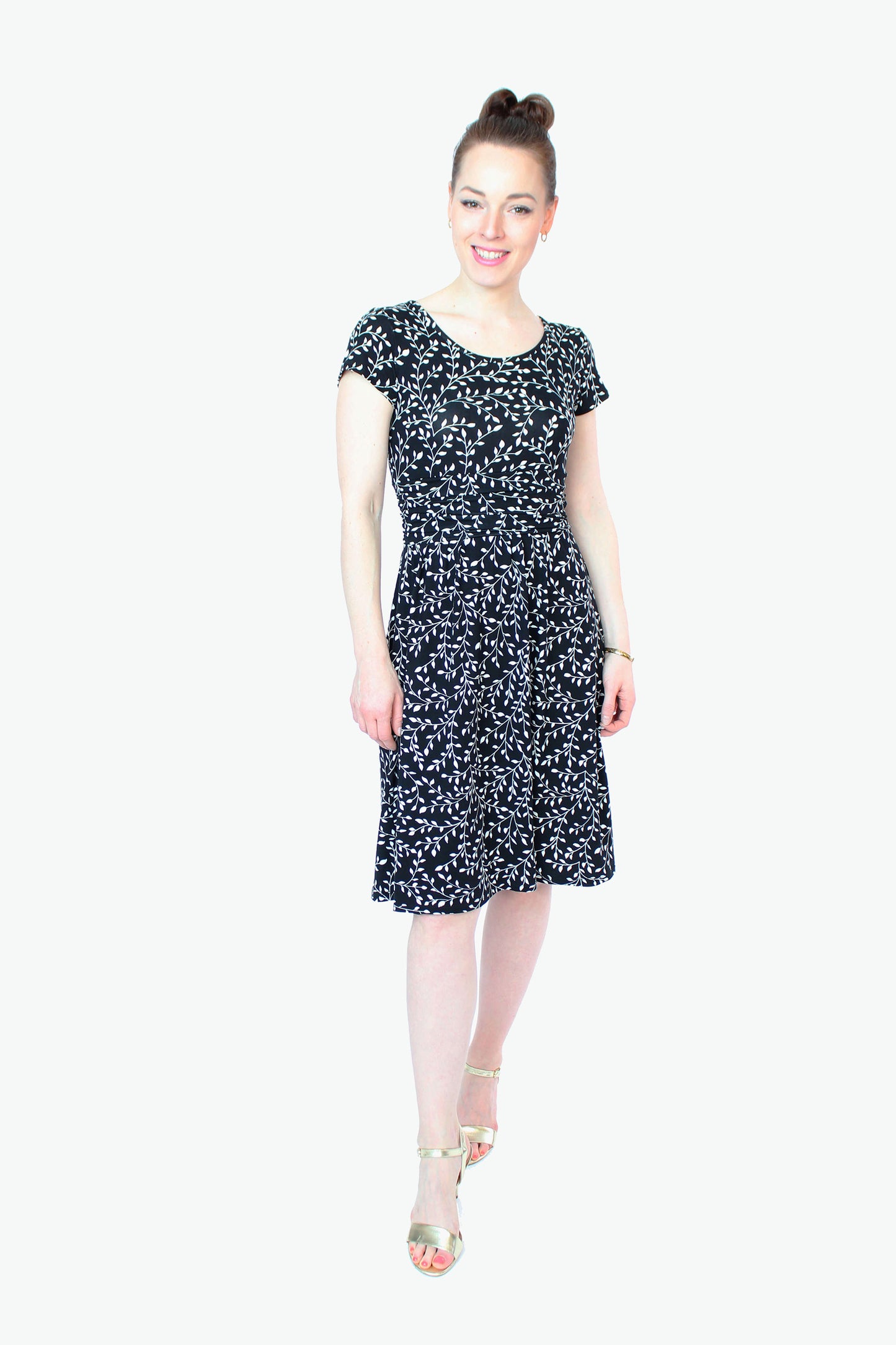 Frau in einem knielangen Jerseykleid in schwarz mit weißen Blumenprint von LA.LUKA Berlin.