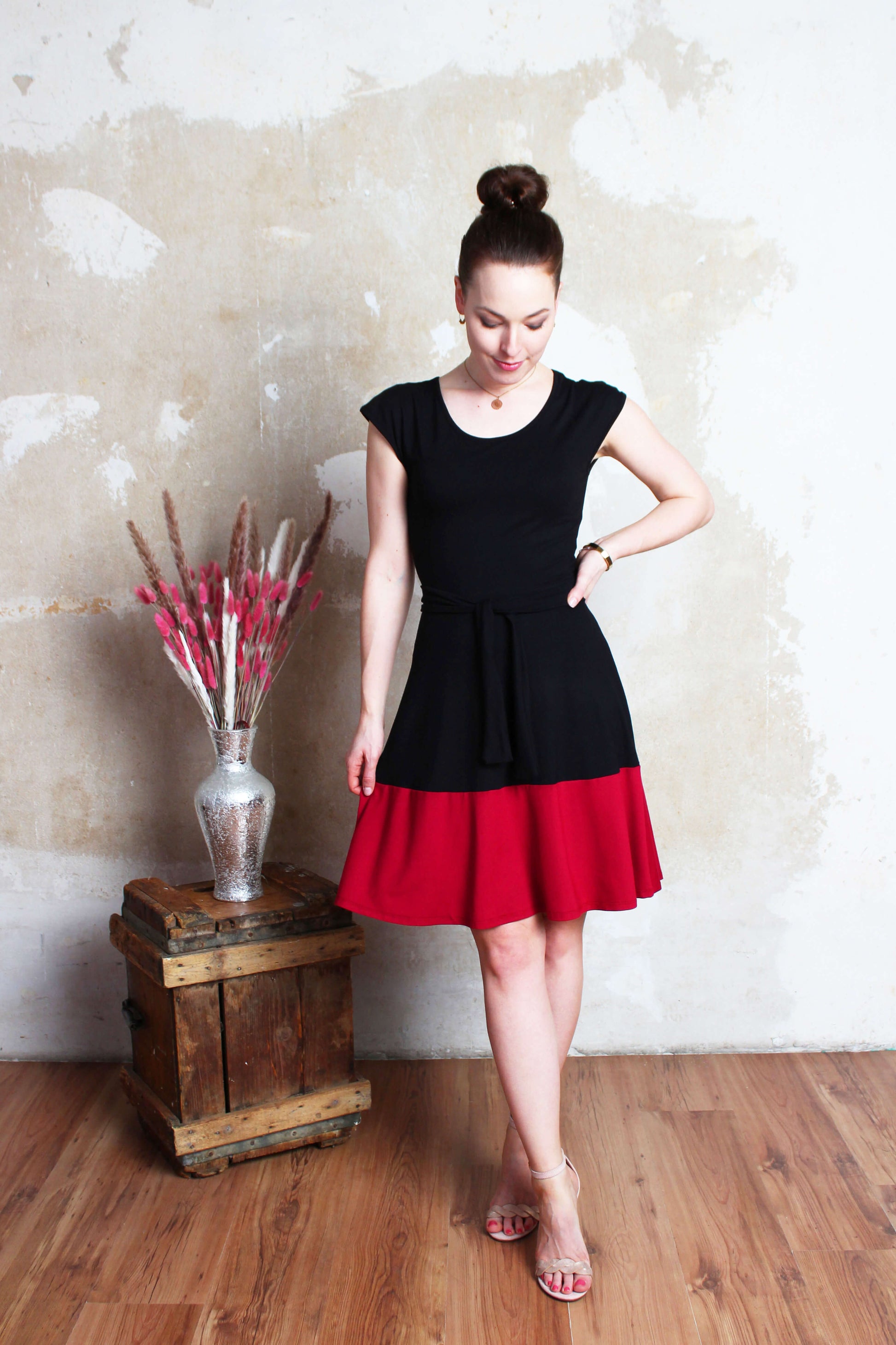 Model, in einem Sommerkleid in schwarz/rot mit kurzen Ärmeln und Rundhalssausschnitt von LA.LUKA Berlin.