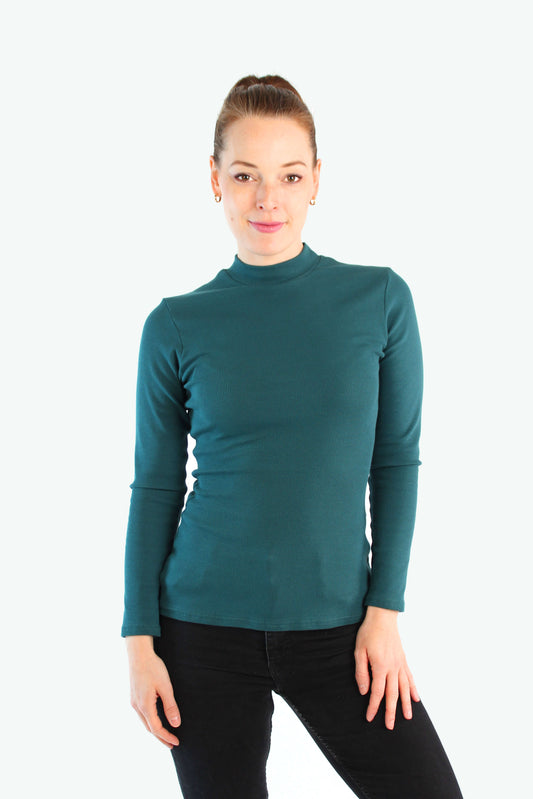 Model trägt dunkelgrünes Stehkragen‐Top aus Jerseyripp von LA.LUKA Berlin vor hellem Hintergrund