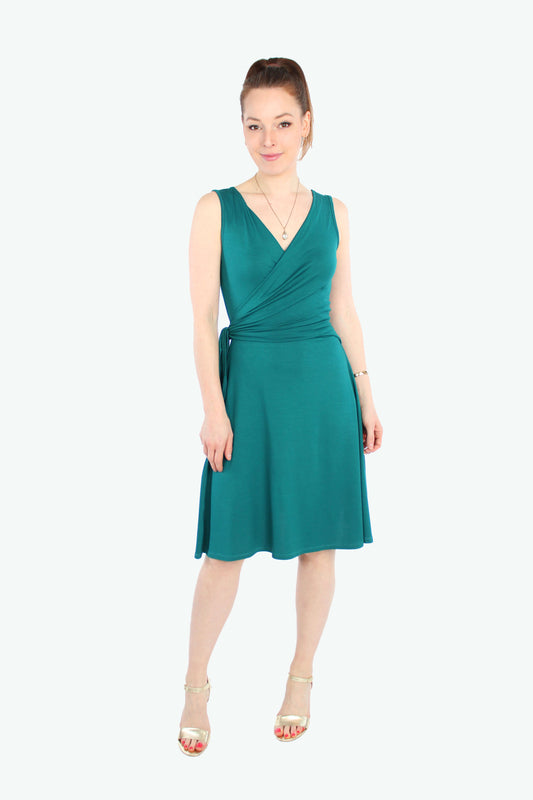 Model, in einem sommerlichen Wickelkleid in petrol aus fließenden Viskosejersey ohne Ärmel.