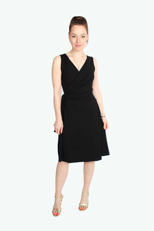 Model, in einem eleganten Wickelkleid in schwarz aus fließenden Viskosejersey ohne Ärmel.