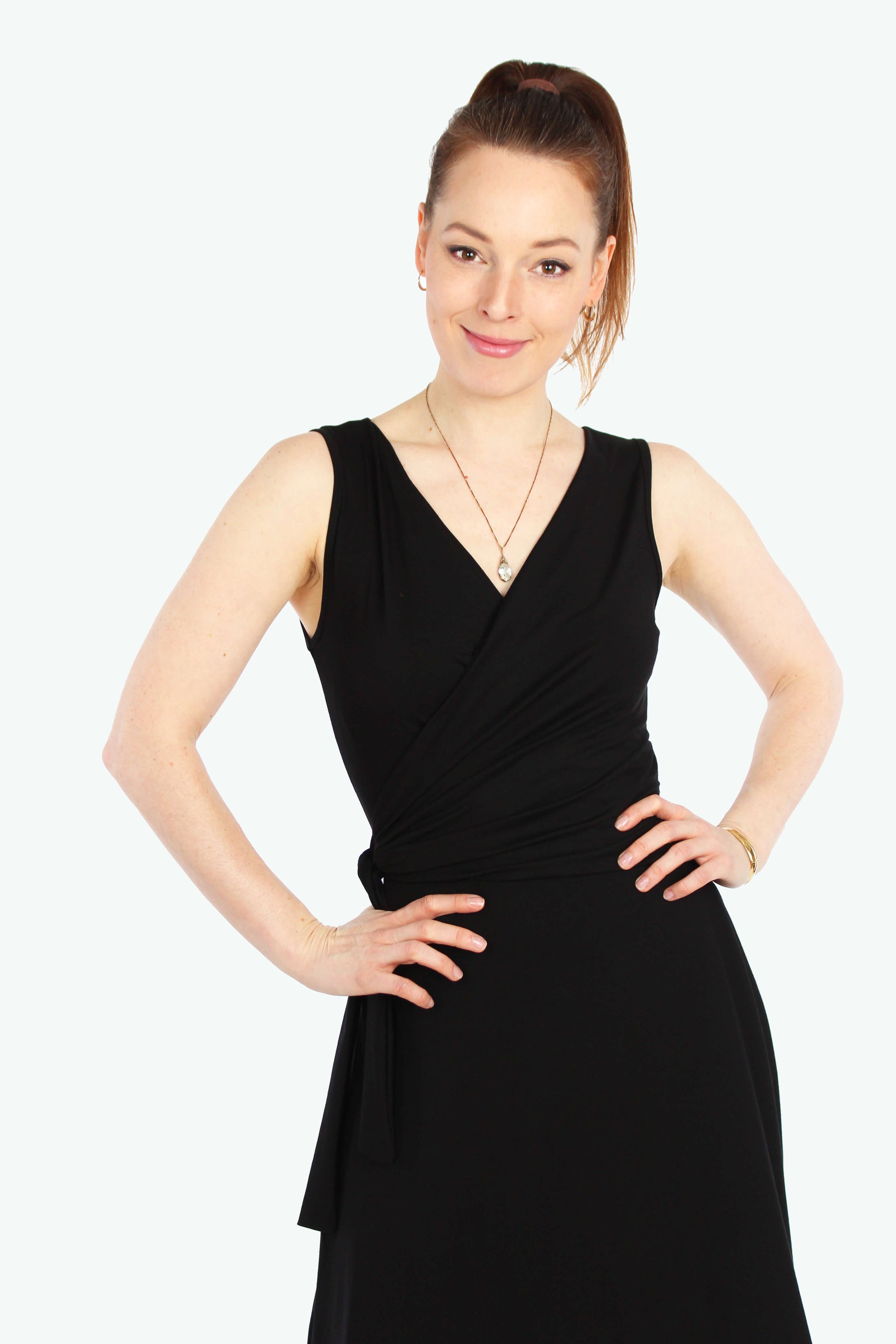 Model, in einem eleganten Wickelkleid in schwarz aus fließenden Viskosejersey ohne Ärmel.