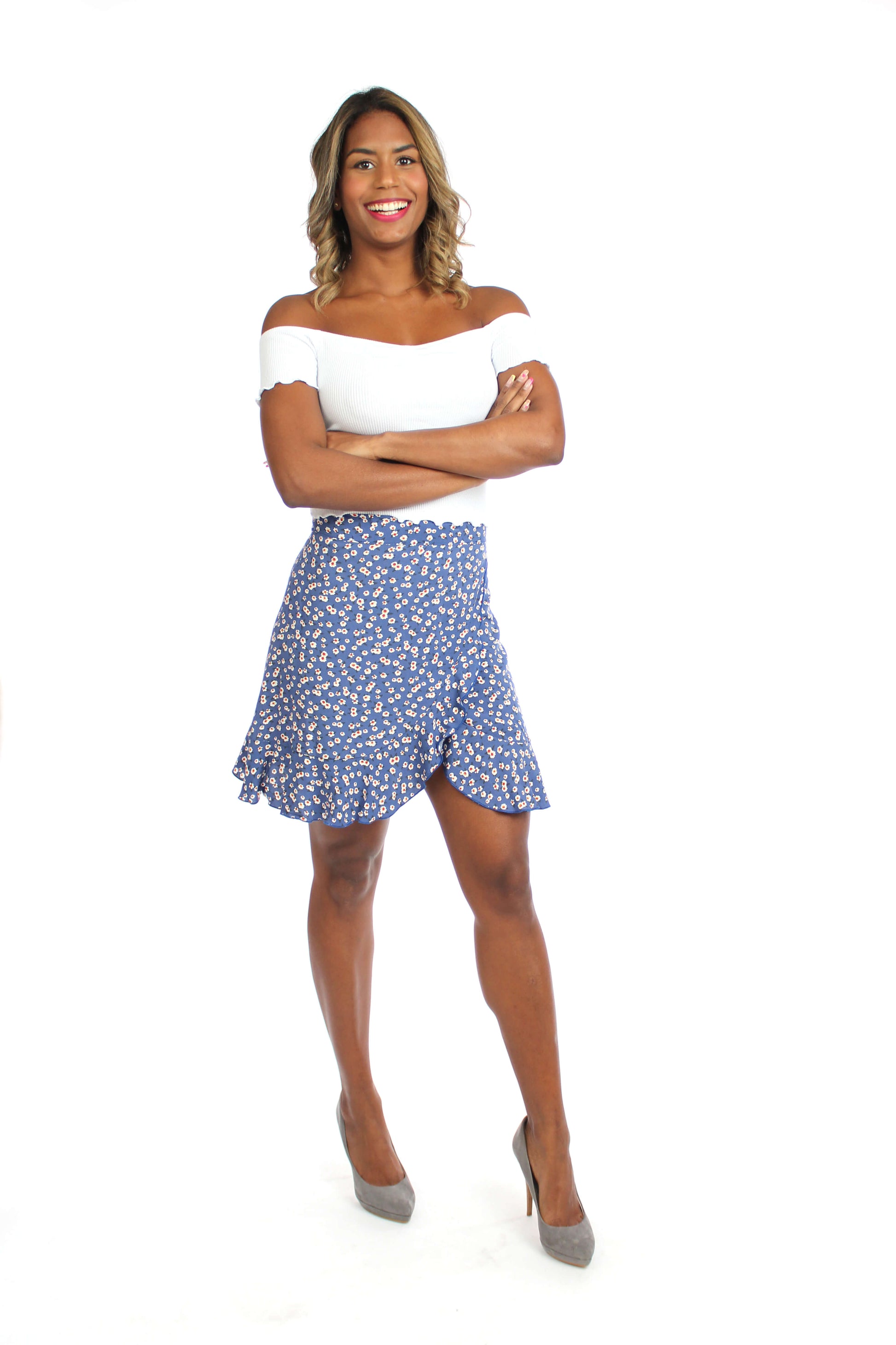 Model in einem sommerlichen, kurzen Wickelrock in blau mit Blumenmuster aus Viskosestoff von LA.LUKA Berlin.