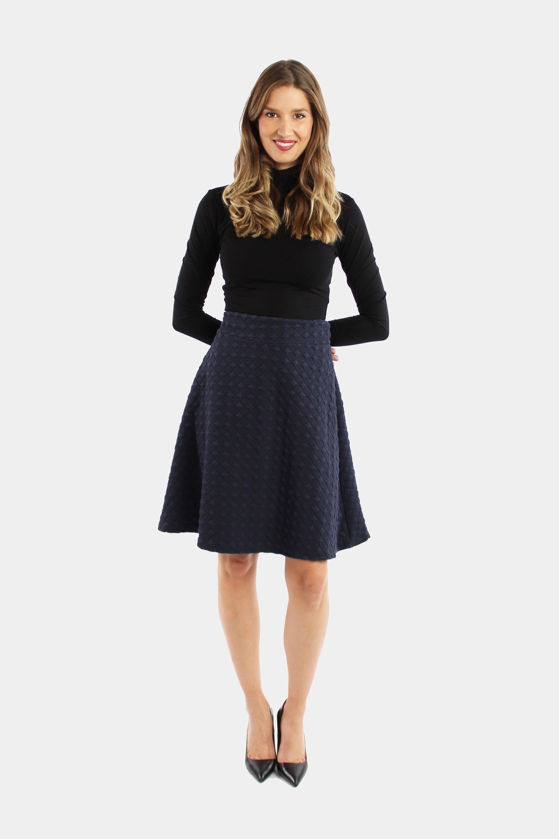 eine Frau präsentiert sich in einem eleganten, dunkelblauen A-Linienrock aus festem Jersey. Ein stilvolles Outfit für besondere Anlässe und einen bleibenden Eindruck.