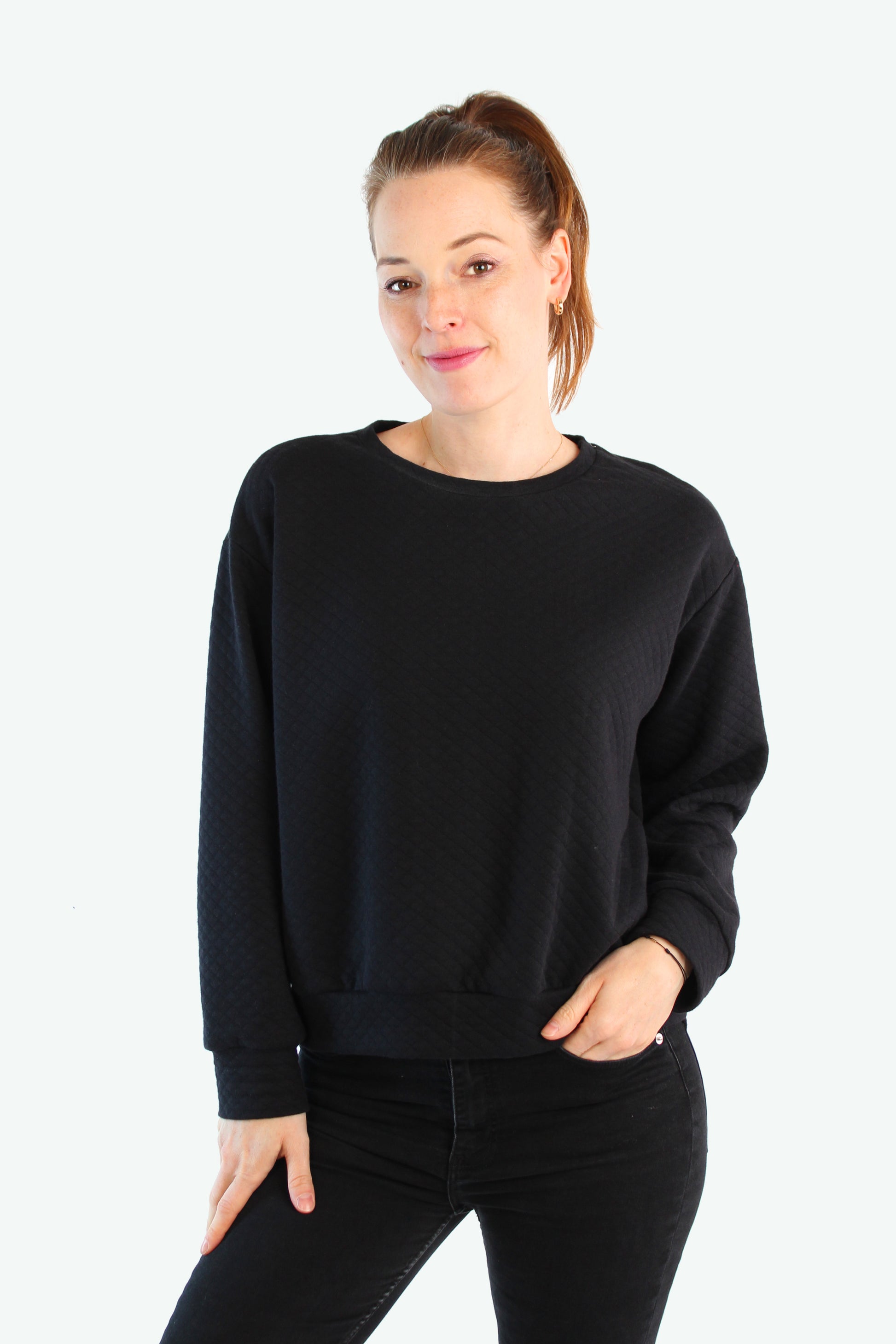 Schwarzer Damenpullover mit Rundhalsausschnitt, locker geschnitten – getragen von einem Model in entspannter Pose, LA.LUKA Berlin