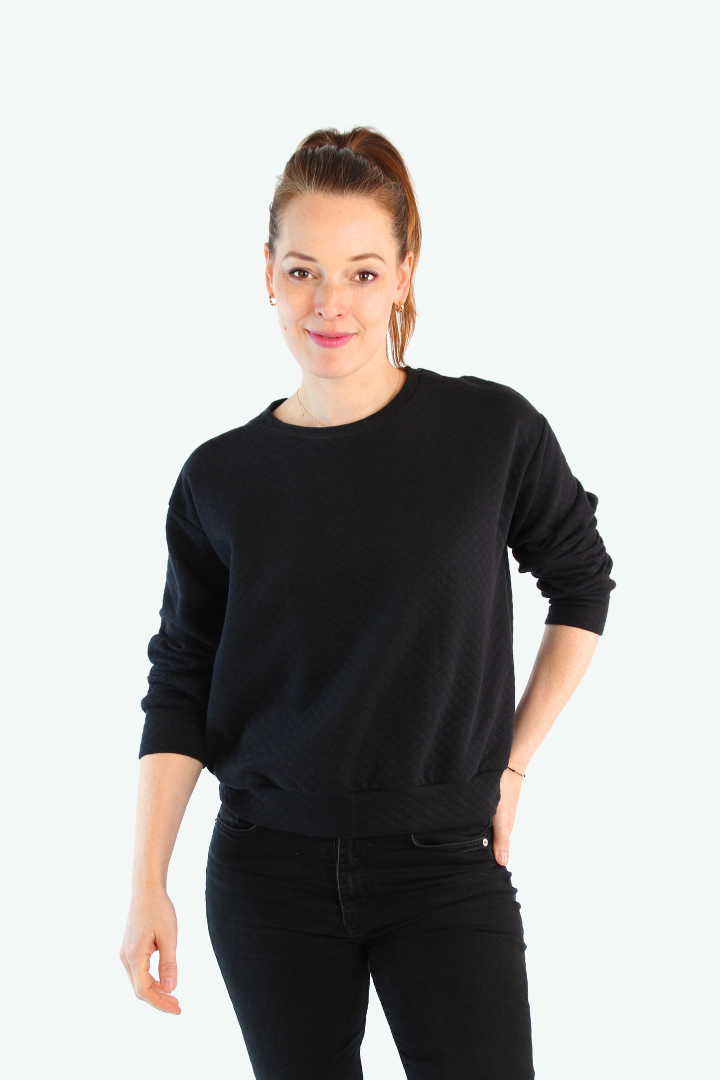 Model trägt schwarzen Sweatpullover aus Baumwollmix mit Strukturmuster – cleanes, helles Fotostudio-Setting – LA.LUKA Berlin.