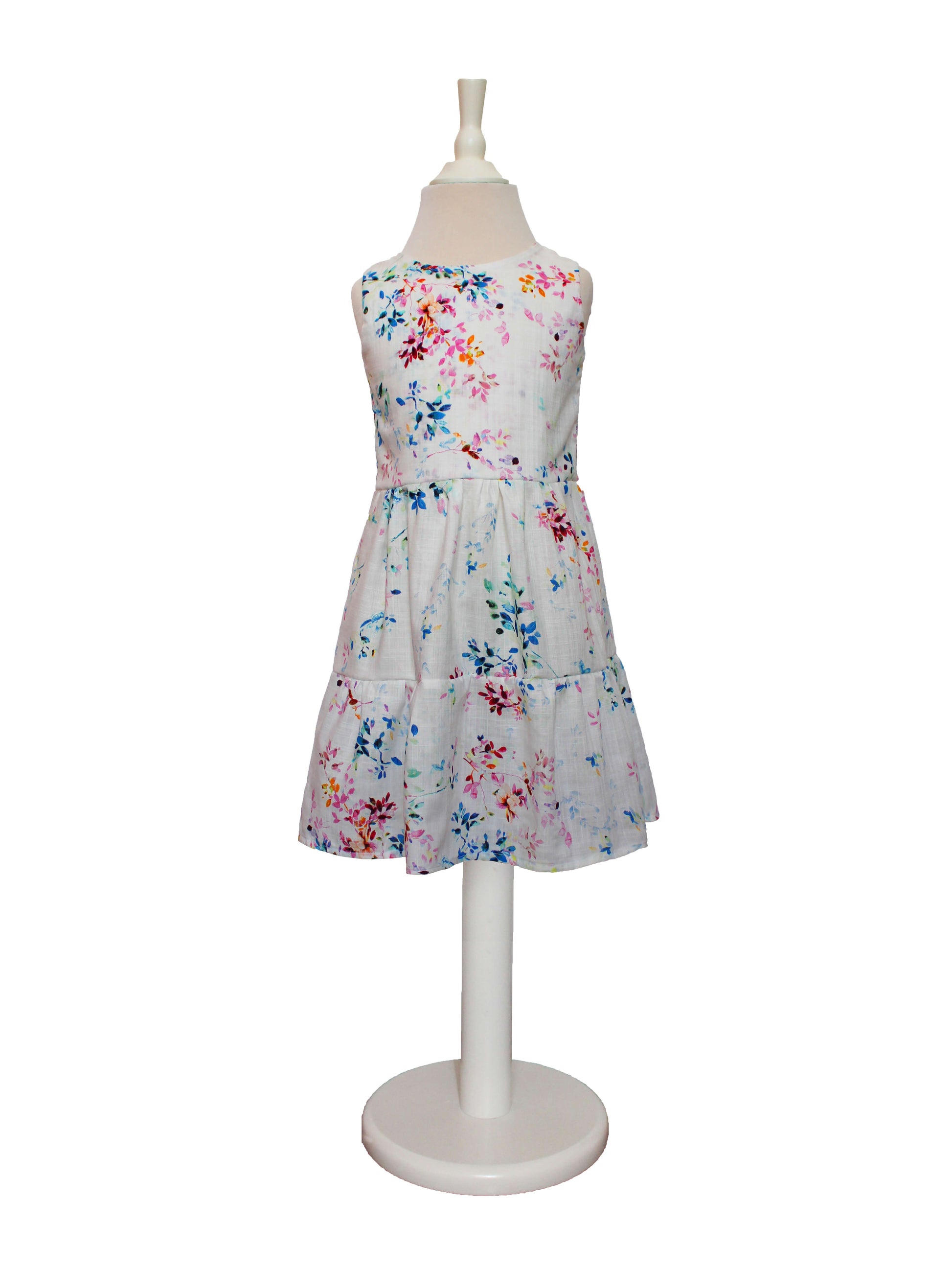 Blumenkleid in weiß mit bunten Blumen von LA.LUKA Berlin Kids auf einer Schneiderpuppe.