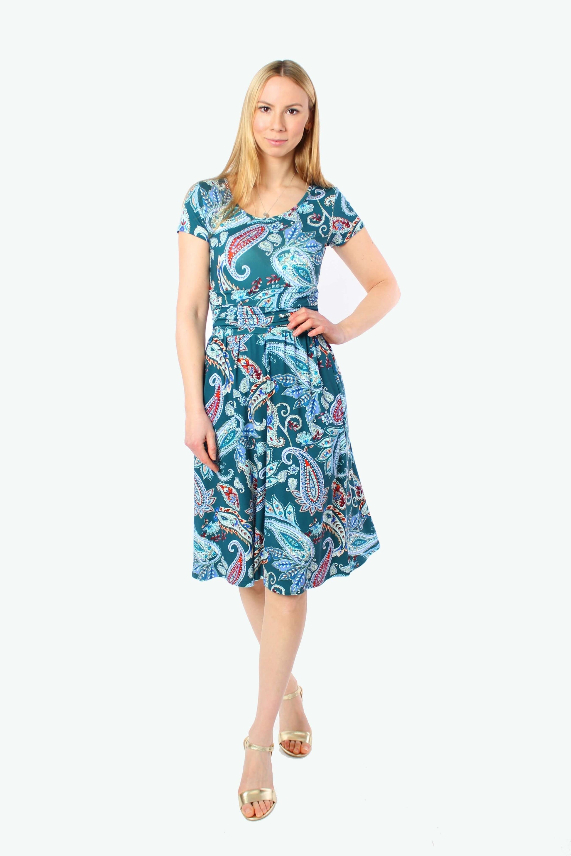 Model in einem Jersey Sommerkleid mit Raffung in der Taille, türkisfarbener Paisley-Print, leicht ausgestellter Rockteil.