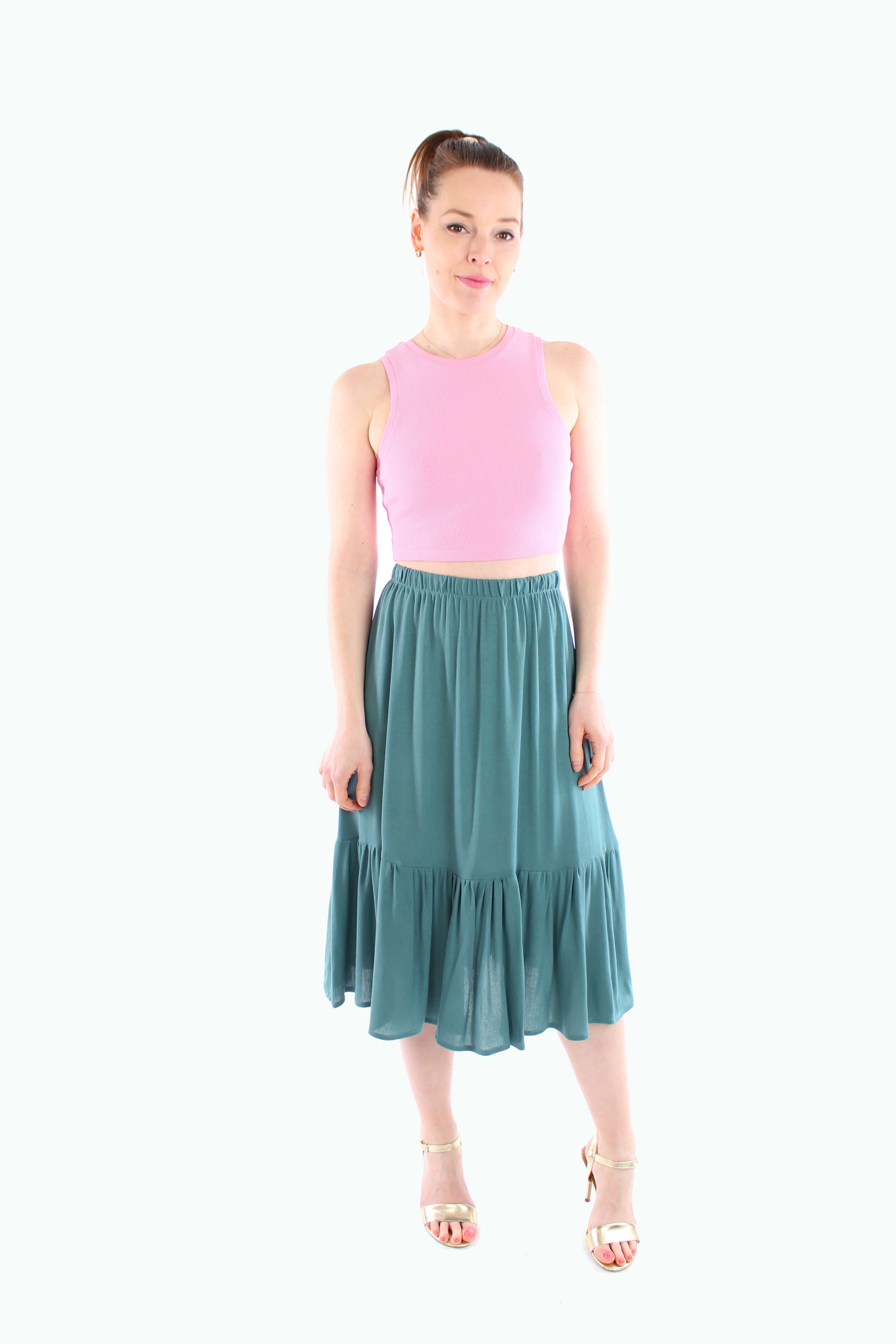 Damen-Midirock in Salbeigrün, kombiniert mit einem rosa Croptop – frischer, farbenfroher Look für Frühling und Sommer.