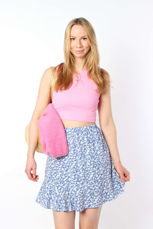 Hellblauer Mini-Sommerrock aus Viskose mit Blumenmuster und Gummibund, locker fallender Schnitt in Bewegung.