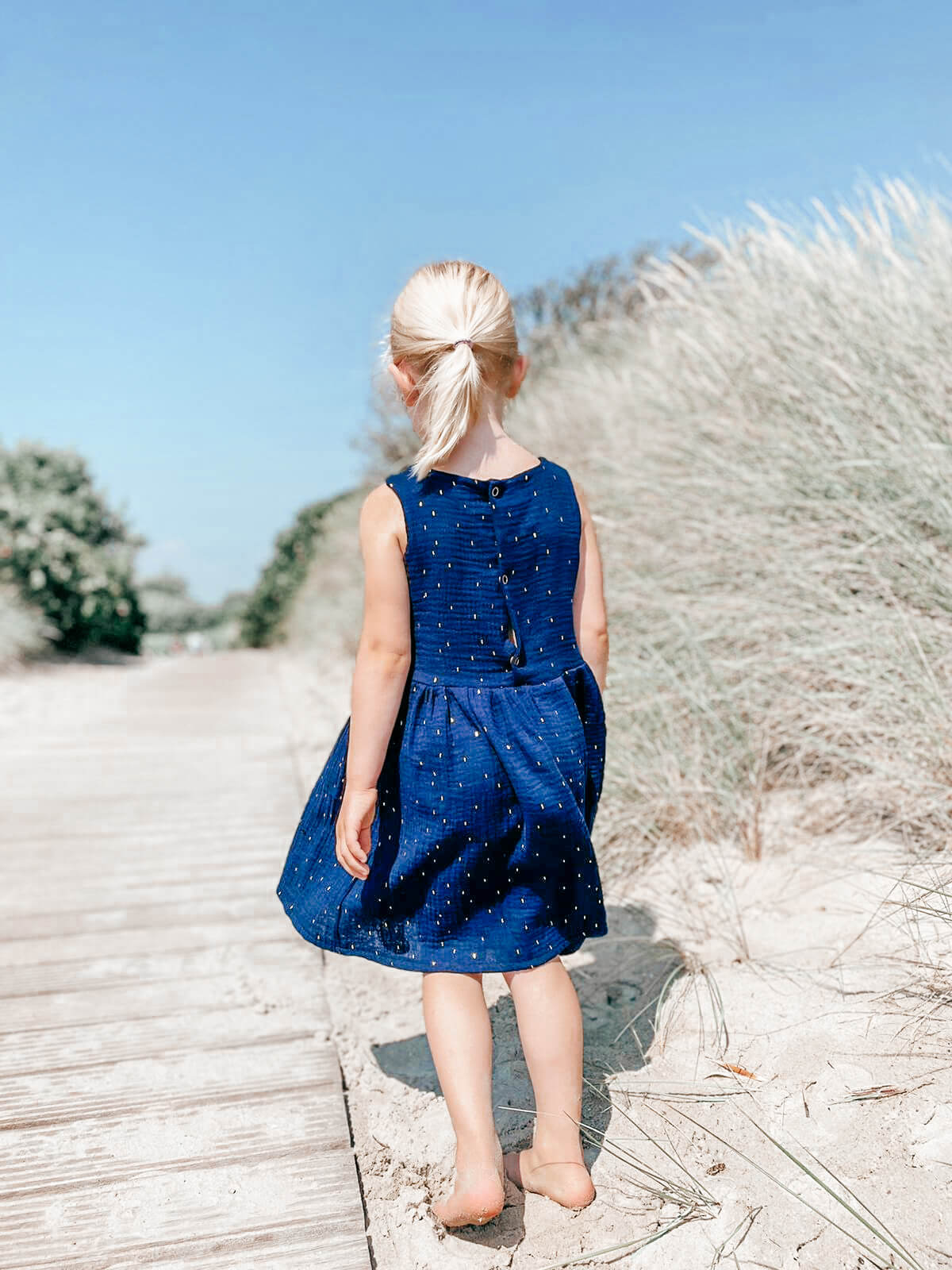 Kinderkleid in dunkelblau mit goldenen Punkten aus Musselinstoff von LA.LUKA Berlin.