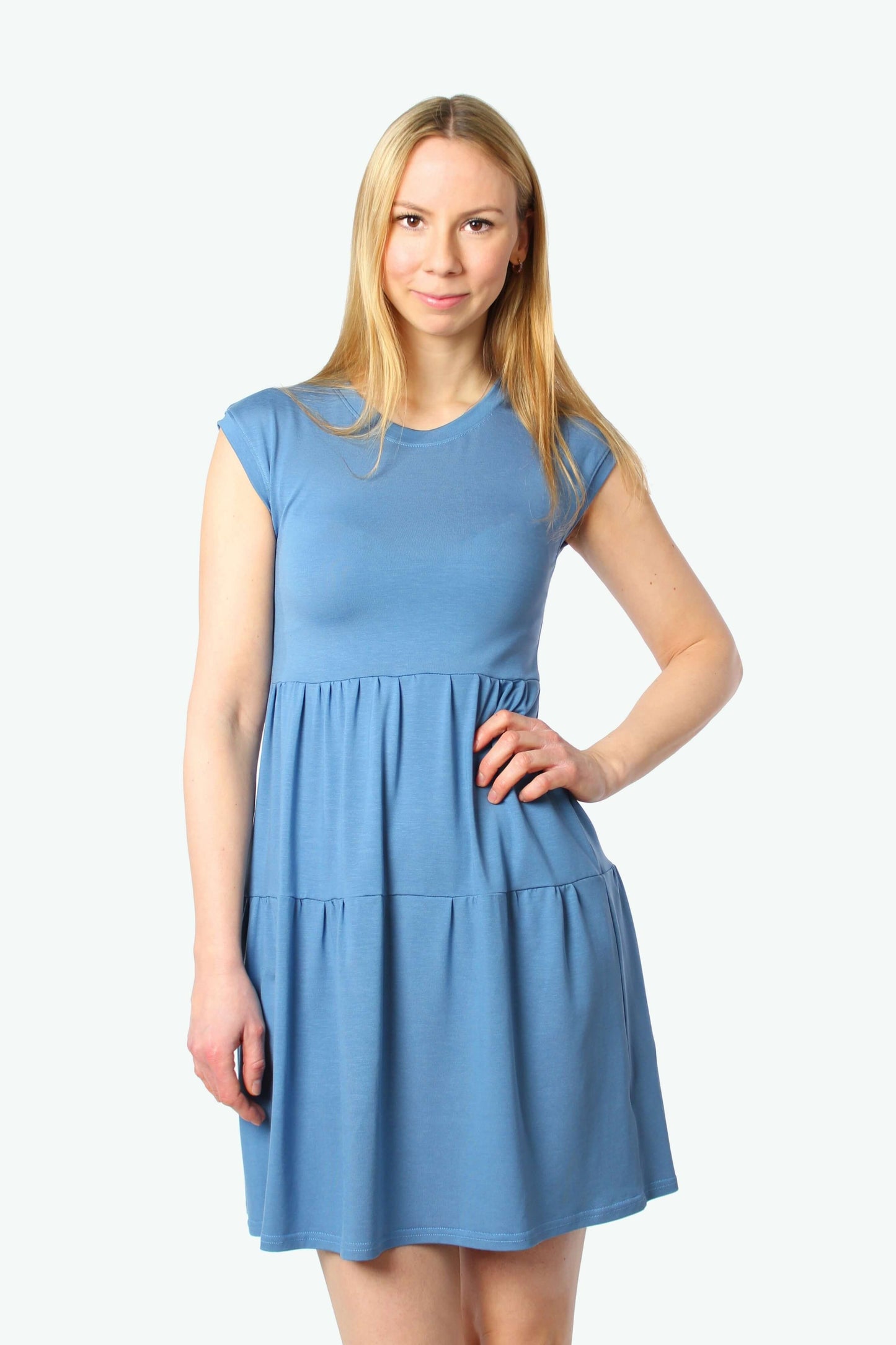 Hellblaues Stufenkleid mit rundem Ausschnitt und kurzen Ärmeln. Nahaufnahme des Sommerkleides.