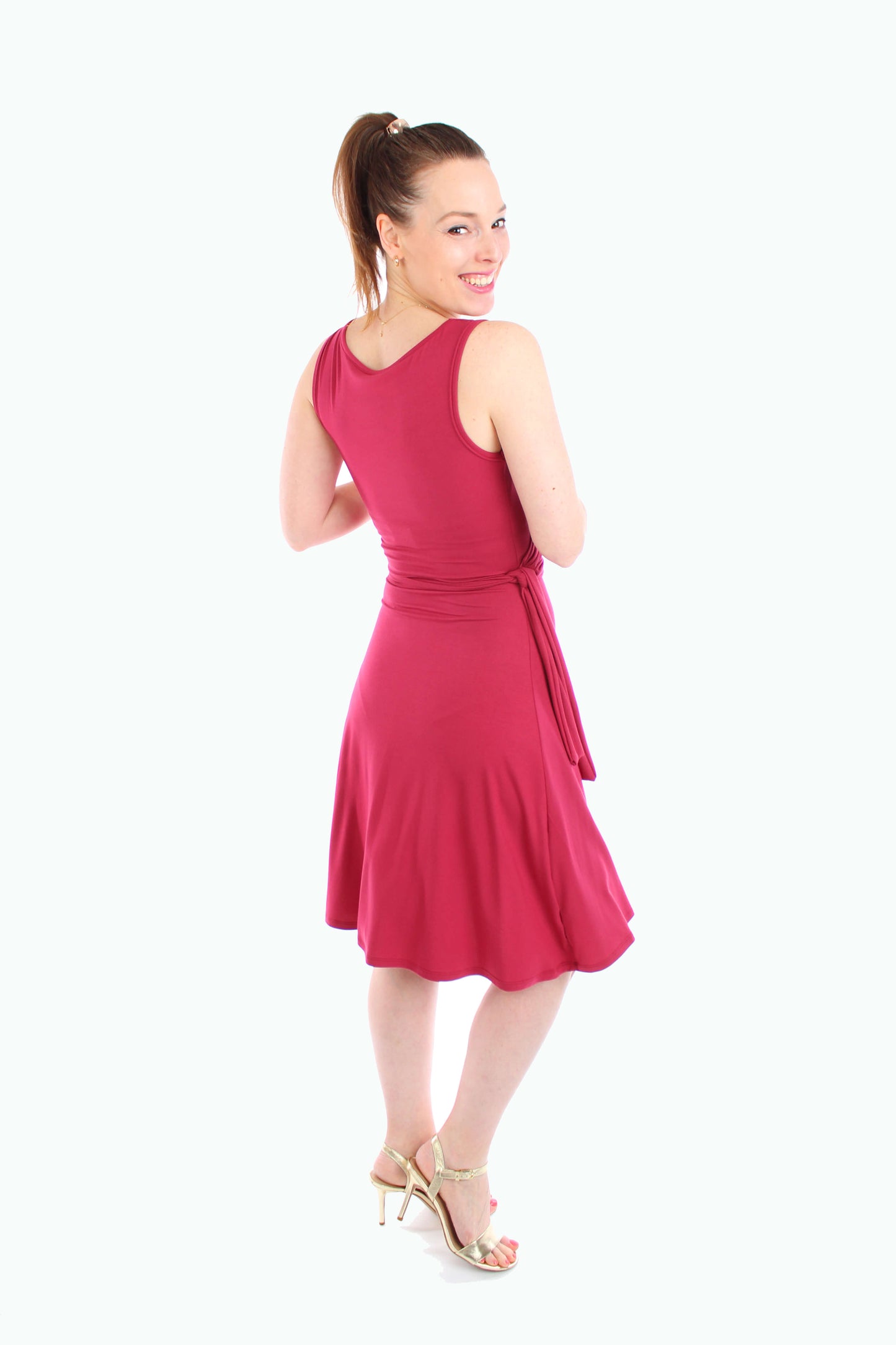 Rückansicht eines roten Damen-Wickelkleids mit taillierter Passform und schwingendem Rock – stilvoller Look für warme Tage.